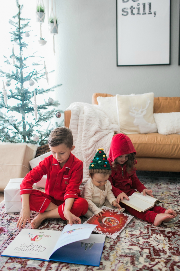 Family | Matching | Shopping | Holiday | The Best Christmas Pajamas for the Whole Family featured by top San Francisco style blog The Girl in the Yellow Dress | The Best Family Christmas Pajamas by popular San Francisco life and style blog, The Girl in the Yellow Dress: image of three kids sitting together by a Christmas tree and wearing Pottery Barn Kids Red Solid Flannel Pajama, Potter Barn Kids Solid Red Nightgown, and Old Navy Zip-Front Footed One-Piece for Baby.