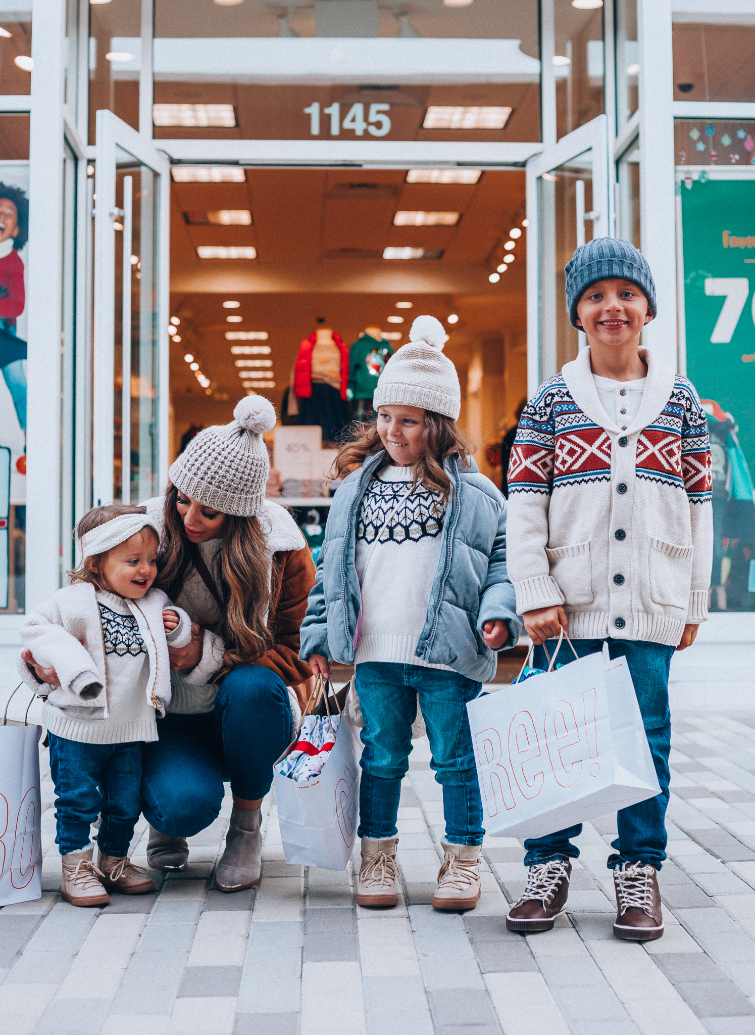 Gymboree Holiday Collection featured by top San Francisco fashion blog, The Girl in the Yellow Dress: image of a mom wearing a Abercrombie & Fitch mock neck sweater, high waist ankle jeans, Mark Fisher Chelsea boots, a pom pom beanie and a leather shoulder bag. A toddler wearing a Gymboree headband, sherpa jacket, sweater, jeggings and metallic moon boots. A boy wearing a Gymboree beanie, sweater, jeans and leather high tops. A girl wearing a Gymboree beanie, coat, sweater, jeans and boots