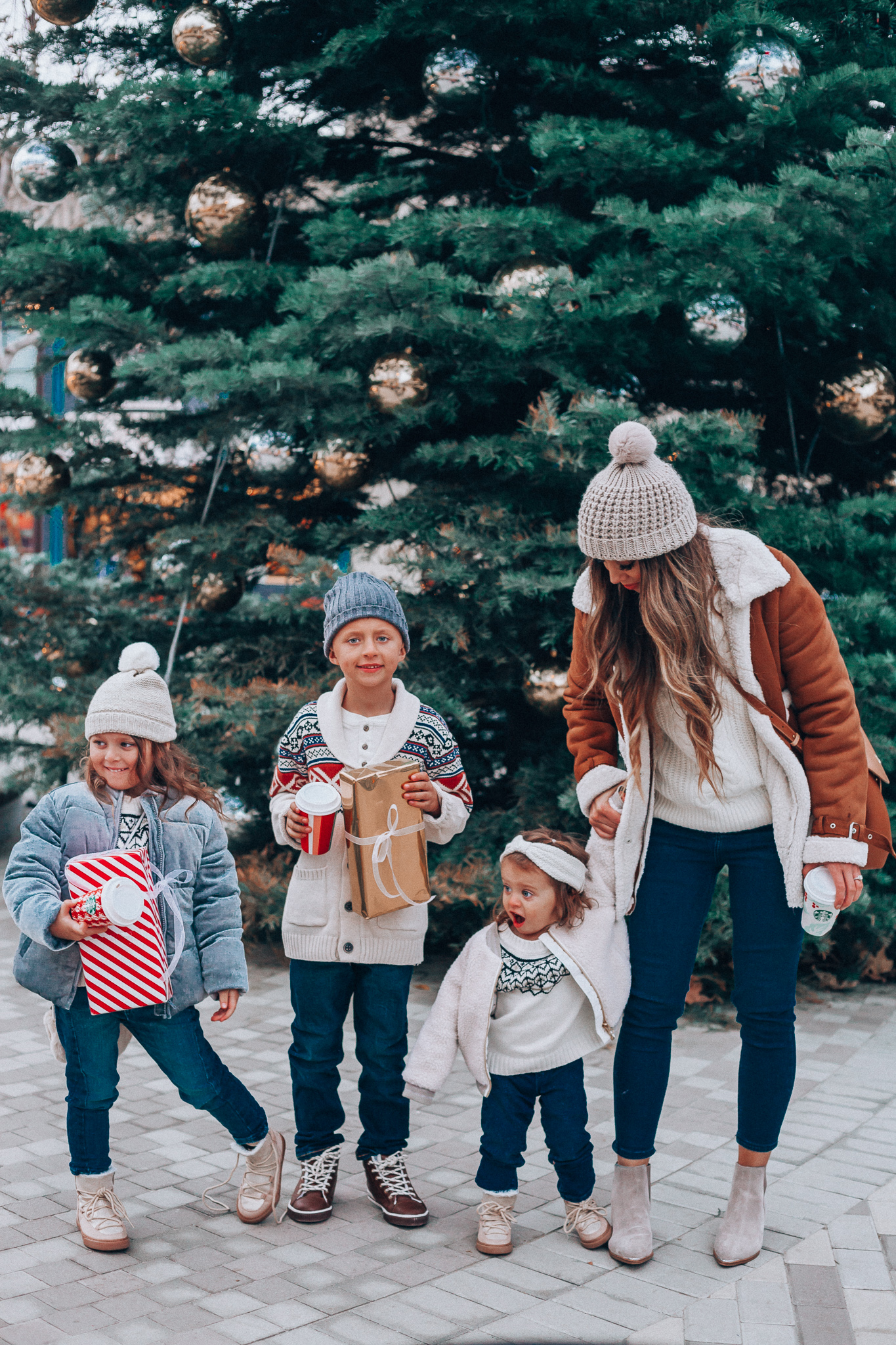 Gymboree Holiday Collection featured by top San Francisco fashion blog, The Girl in the Yellow Dress: image of a mom wearing a Abercrombie & Fitch mock neck sweater, high waist ankle jeans, Mark Fisher Chelsea boots, a pom pom beanie and a leather shoulder bag. A toddler wearing a Gymboree headband, sherpa jacket, sweater, jeggings and metallic moon boots. A boy wearing a Gymboree beanie, sweater, jeans and leather high tops. A girl wearing a Gymboree beanie, coat, sweater, jeans and boots