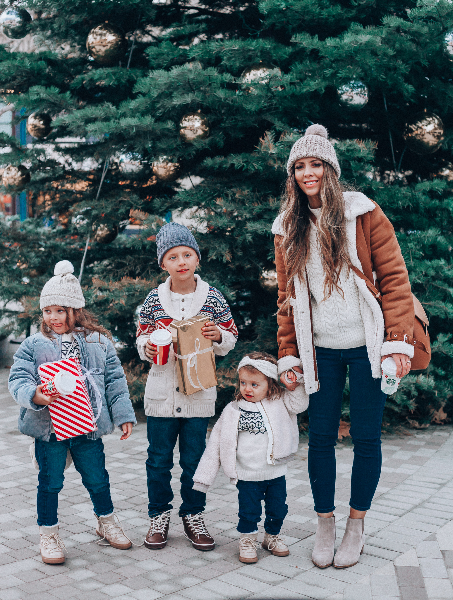 Gymboree Holiday Collection featured by top San Francisco fashion blog, The Girl in the Yellow Dress: image of a mom wearing a Abercrombie & Fitch mock neck sweater, high waist ankle jeans, Mark Fisher Chelsea boots, a pom pom beanie and a leather shoulder bag. A toddler wearing a Gymboree headband, sherpa jacket, sweater, jeggings and metallic moon boots. A boy wearing a Gymboree beanie, sweater, jeans and leather high tops. A girl wearing a Gymboree beanie, coat, sweater, jeans and boots