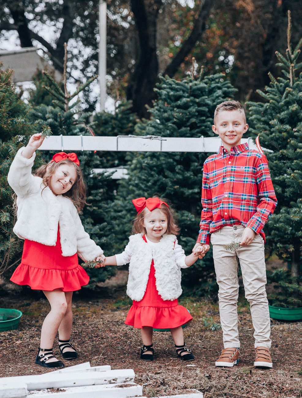 Cute Family Christmas Outfits featured by top San Francisco fashion blog, The Girl in the Yellow Dress: image of a woman wearing a Vineyard Vines paid dress, Cecelia booties, Vineyard Vines tassel earrings; a man wearing Vineyard Vines plaid shirt, sweater and slim fit pants, Cole Haan sneakers; a little boy wearing a Vineyard Vines plaid shirt and corduroy pants; a little girl wearing a Vineyard Vines party dress, GAP faux fur jacket, and Old Navy buckle flats