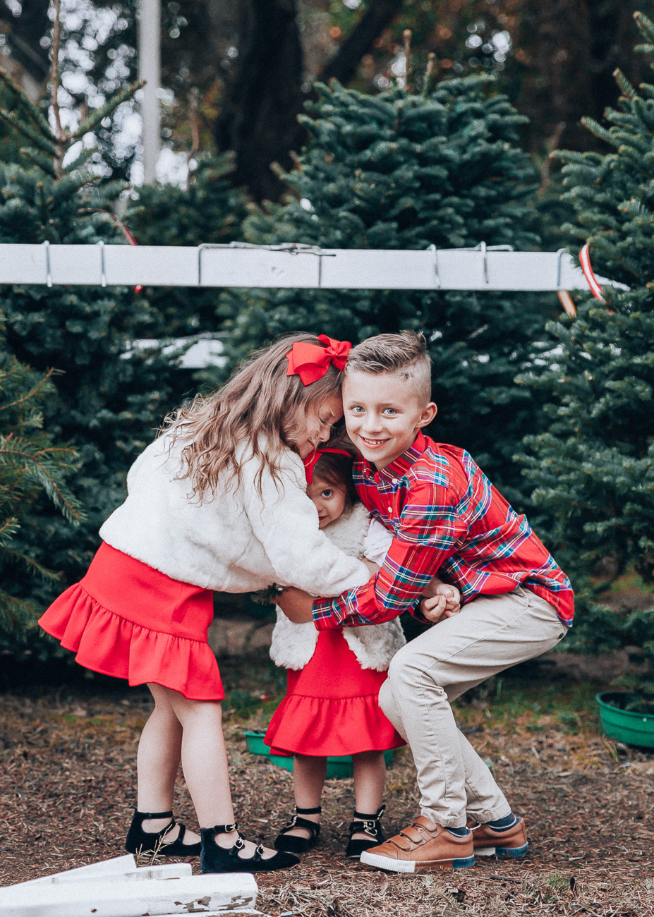 Cute Family Christmas Outfits featured by top San Francisco fashion blog, The Girl in the Yellow Dress: image of a woman wearing a Vineyard Vines paid dress, Cecelia booties, Vineyard Vines tassel earrings; a man wearing Vineyard Vines plaid shirt, sweater and slim fit pants, Cole Haan sneakers; a little boy wearing a Vineyard Vines plaid shirt and corduroy pants; a little girl wearing a Vineyard Vines party dress, GAP faux fur jacket, and Old Navy buckle flats