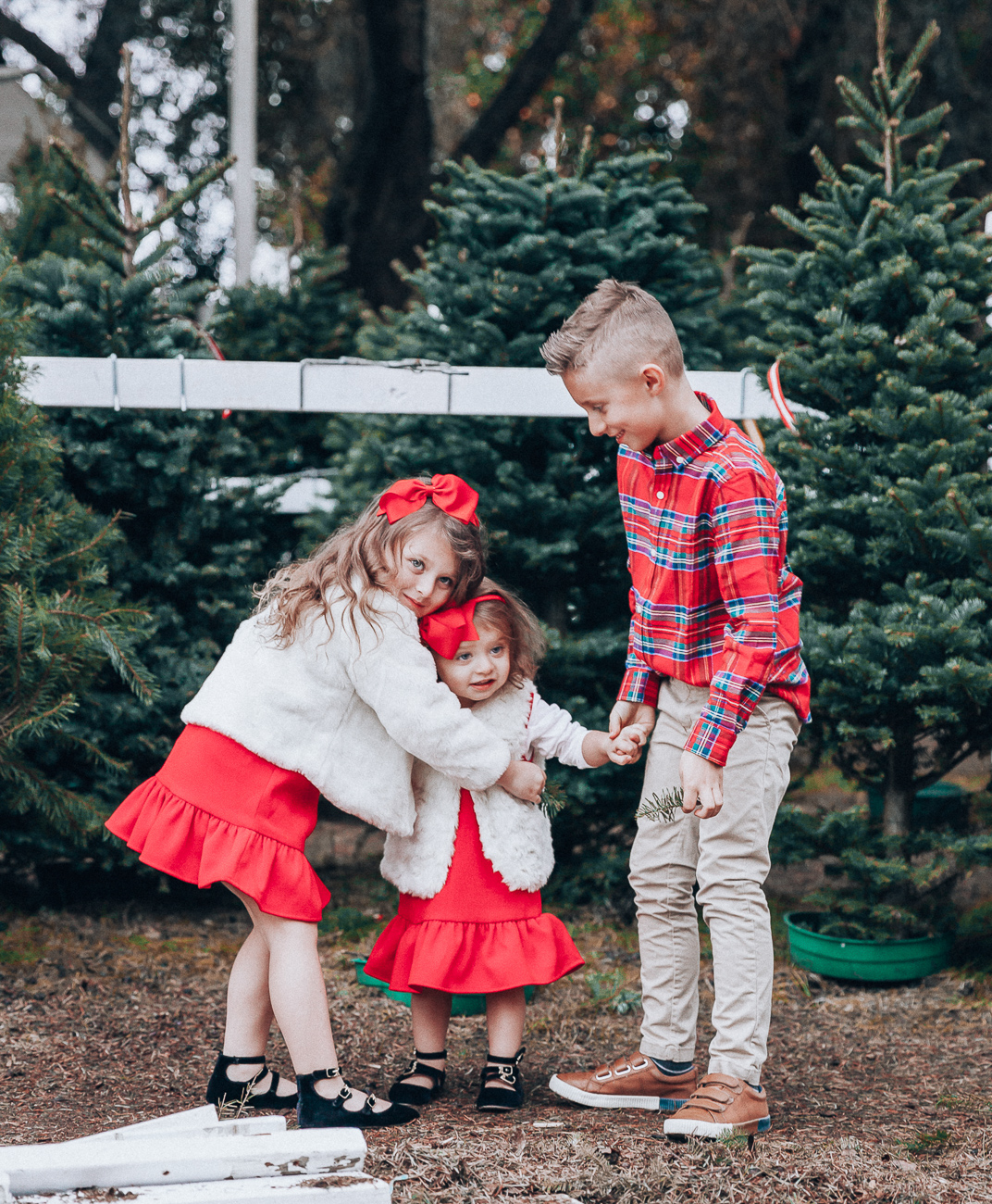 Cute Family Christmas Outfits featured by top San Francisco fashion blog, The Girl in the Yellow Dress: image of a woman wearing a Vineyard Vines paid dress, Cecelia booties, Vineyard Vines tassel earrings; a man wearing Vineyard Vines plaid shirt, sweater and slim fit pants, Cole Haan sneakers; a little boy wearing a Vineyard Vines plaid shirt and corduroy pants; a little girl wearing a Vineyard Vines party dress, GAP faux fur jacket, and Old Navy buckle flats