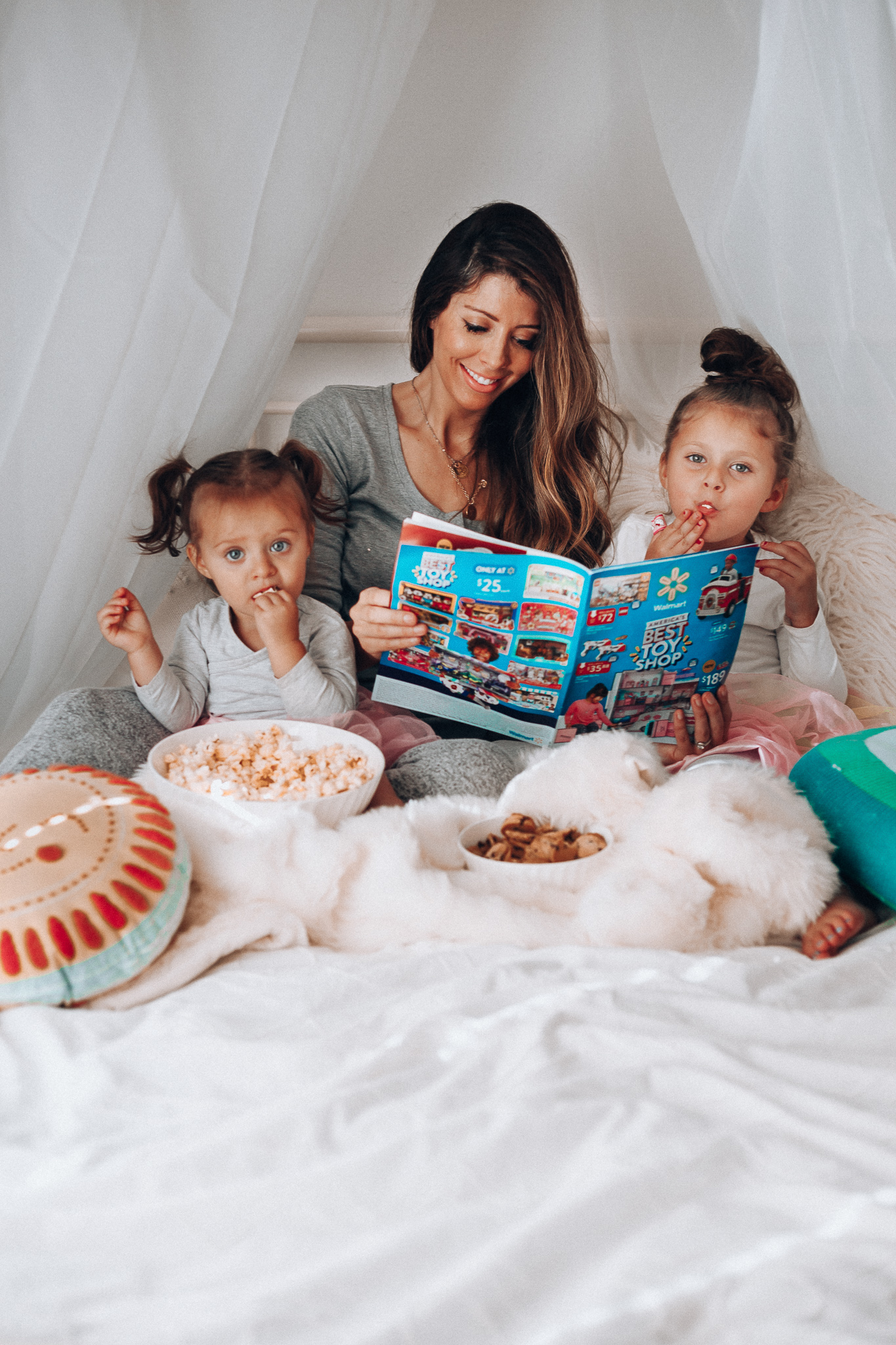 Top 15 Best Toys at Walmart featured by top San Francisco life and style blog, The Girl in the Yellow Dress: image of a mom and children looking at a Walmart toy catalogue