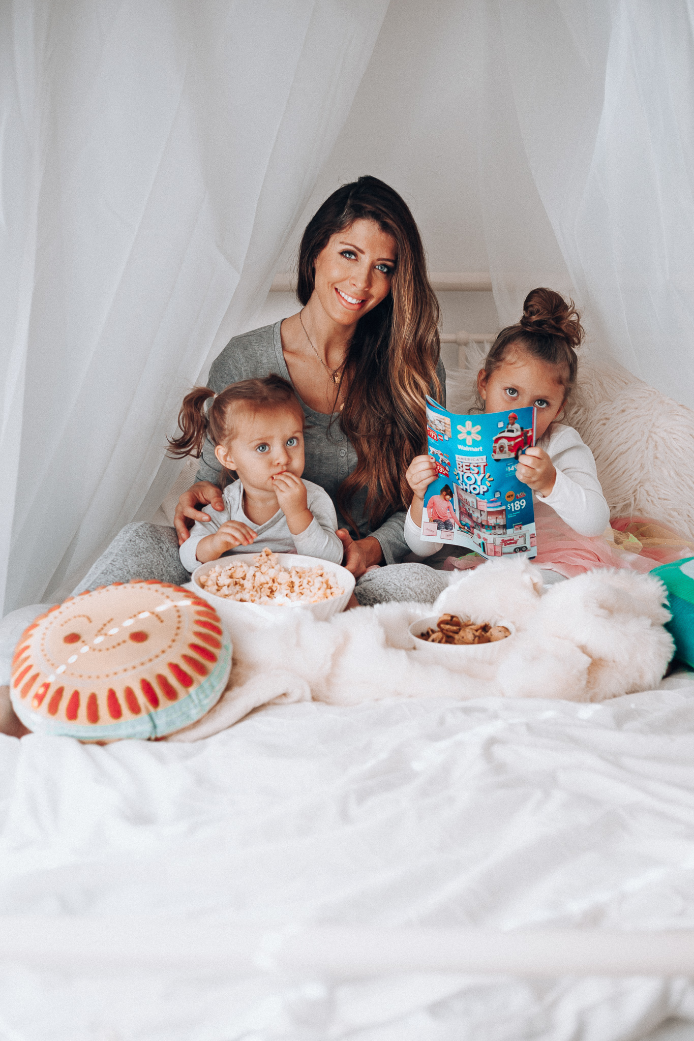 Top 15 Best Toys at Walmart featured by top San Francisco life and style blog, The Girl in the Yellow Dress: image of a mom and children looking at a Walmart toy catalogue