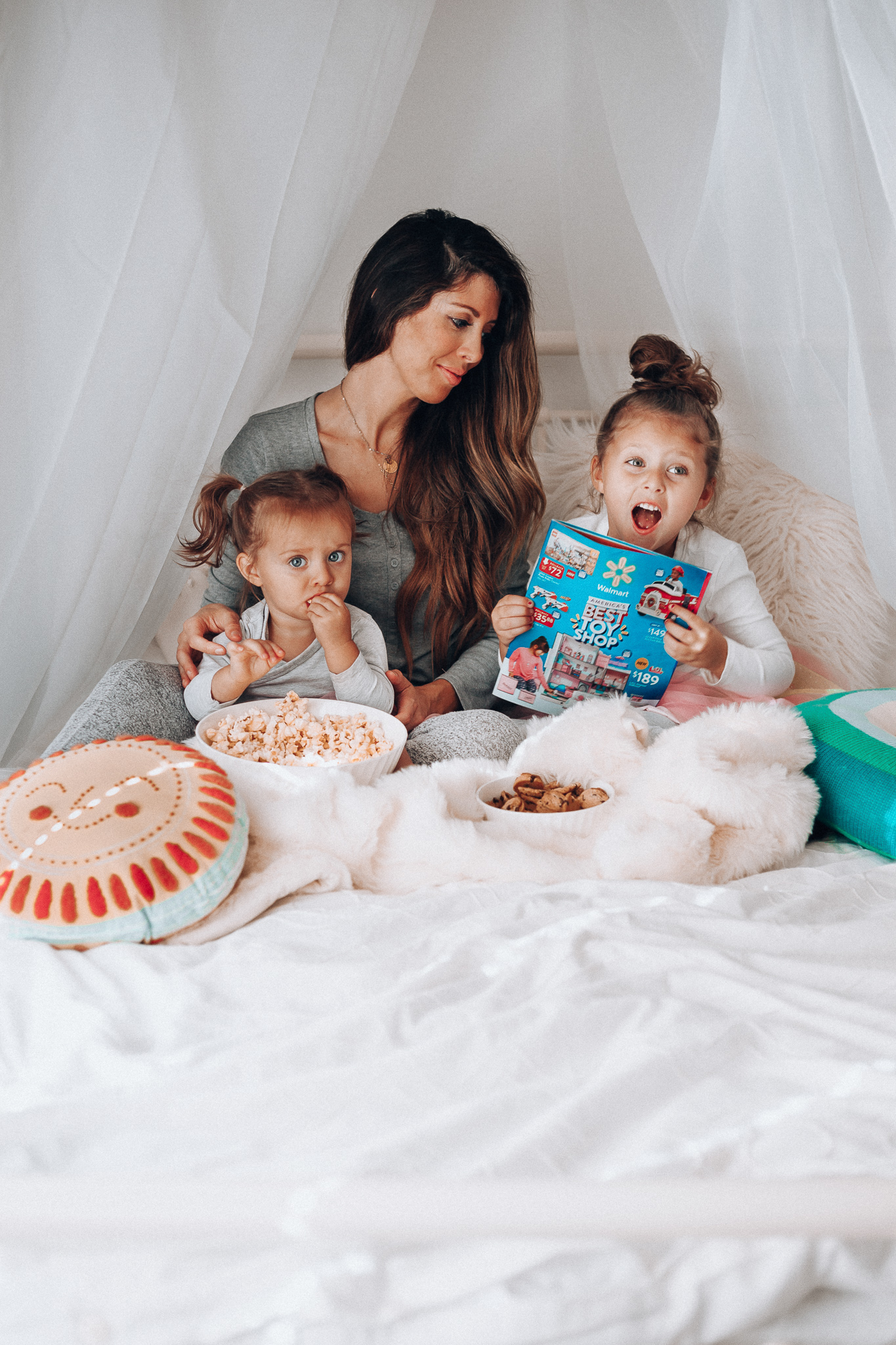 Top 15 Best Toys at Walmart featured by top San Francisco life and style blog, The Girl in the Yellow Dress: image of a mom and children looking at a Walmart toy catalogue