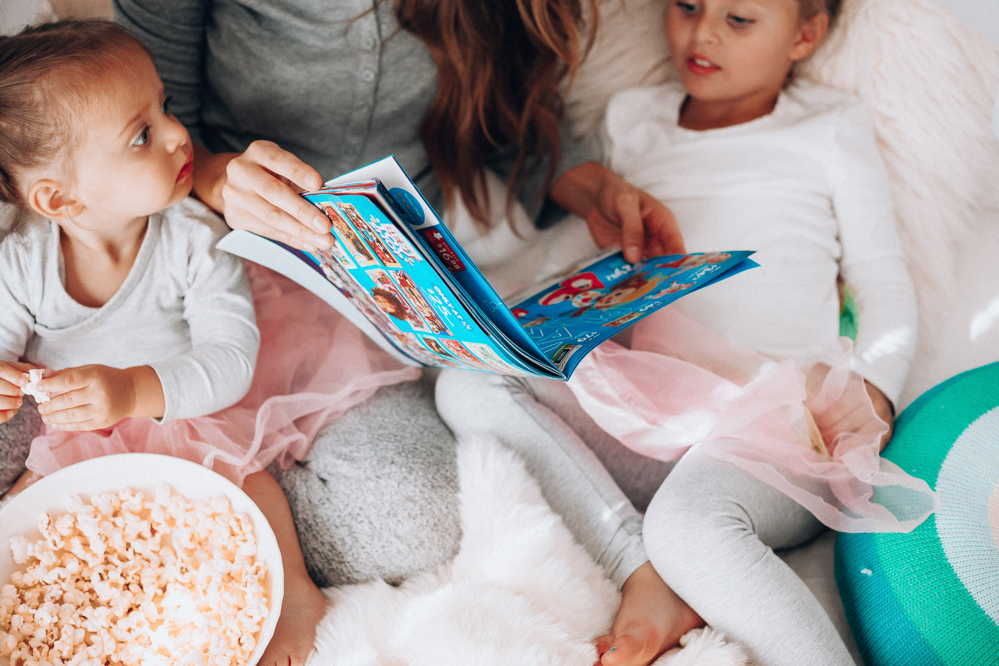 Top 15 Best Toys at Walmart featured by top San Francisco life and style blog, The Girl in the Yellow Dress: image of a mom and children looking at a Walmart toy catalogue