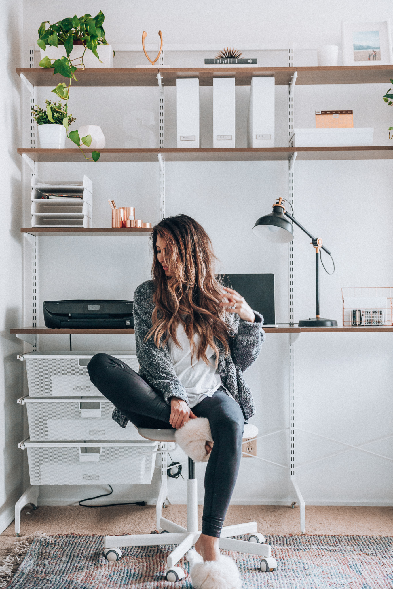 Modern & Fresh Home Office Space Ideas featured by top US lifestyle blog, The Girl in the Yellow Dress: image of a woman sitting on an IKEA office chair by a Container Store freestanding desk