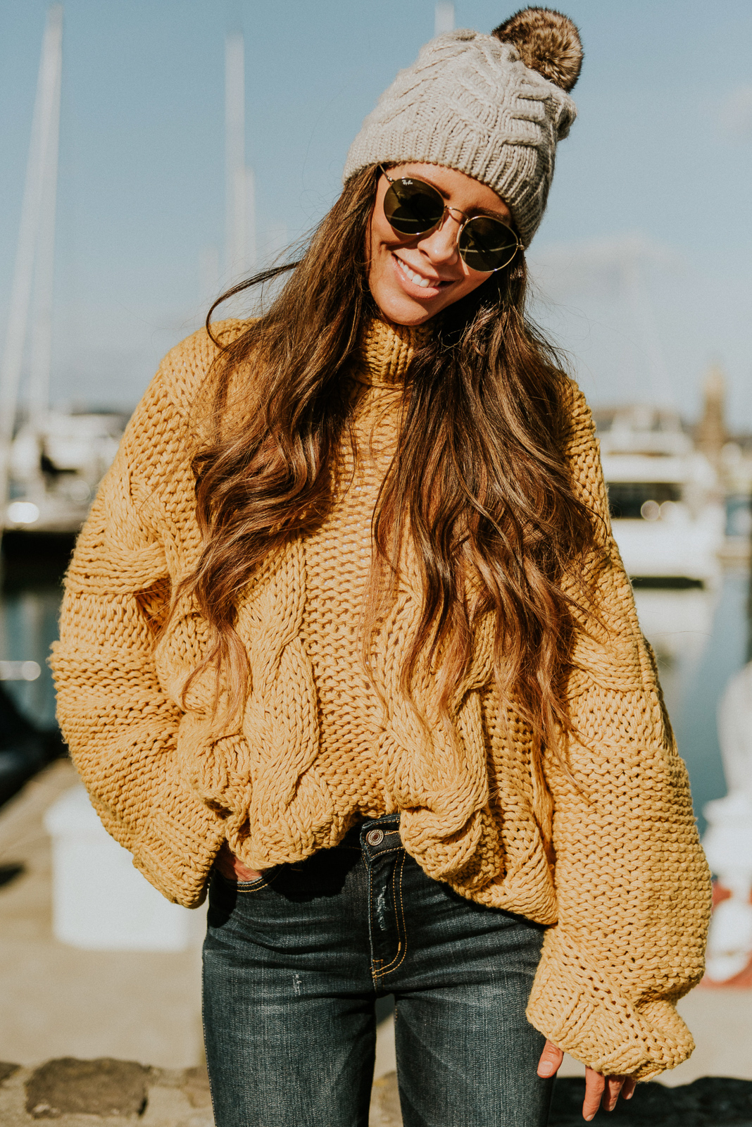 Girls Trip to San Francisco featured by top US fashion blog The Girl in the Yellow Dress; Image of woman wearing pom beanie, cable knit sweater and frayed ankle skinny jeans from Vici and Marc Fisher boots.