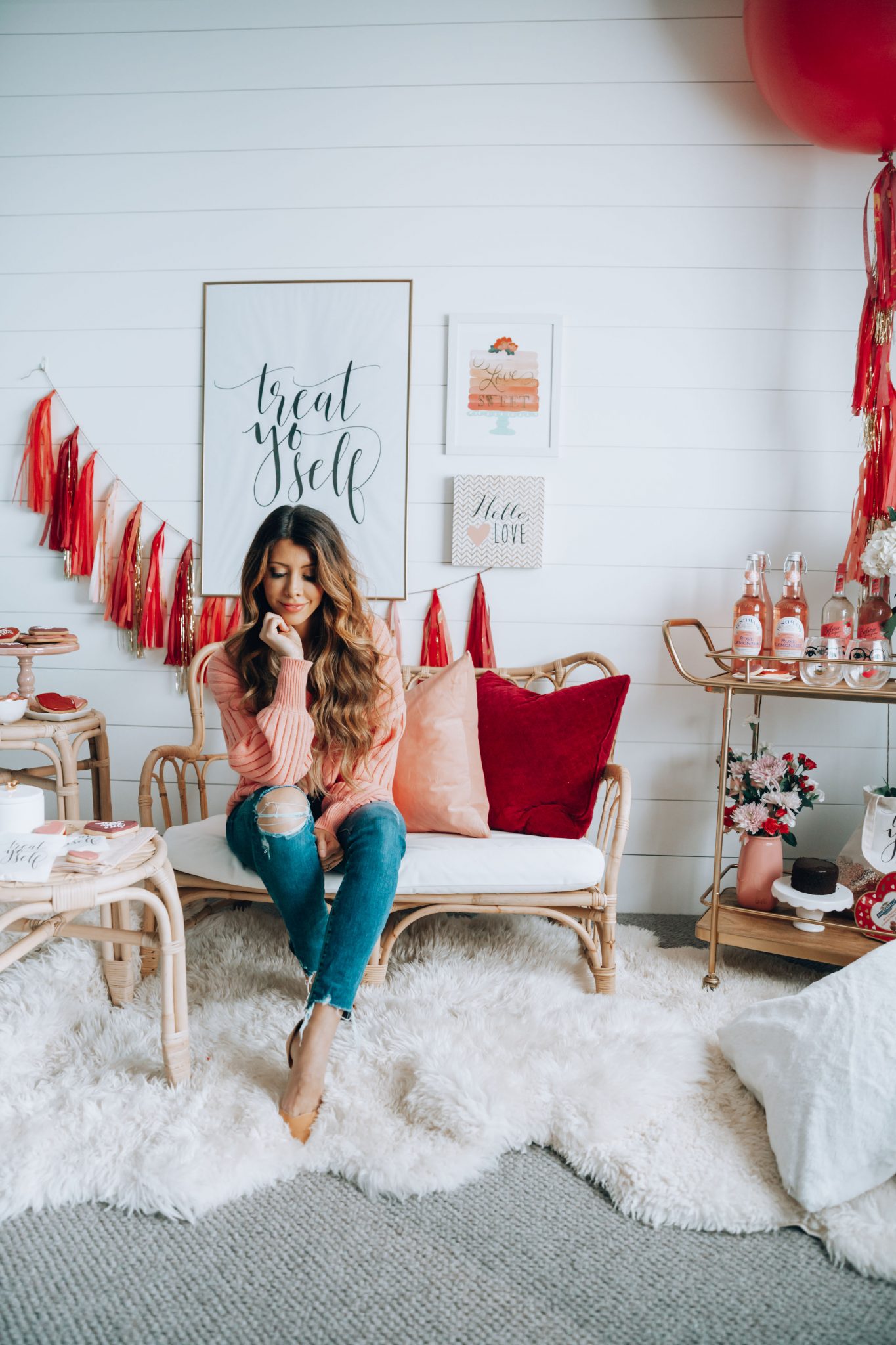 Galentines featured by top US life and style blog The Girl in the Yellow Dress; Image of a woman wearing a pink sweater and jeans.