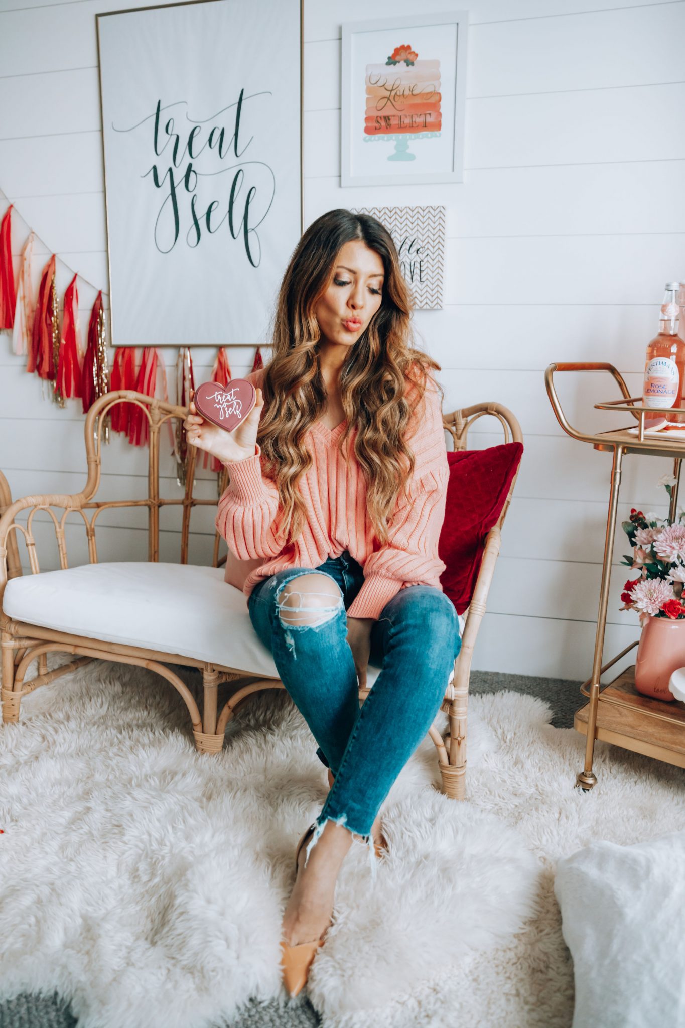 Galentines featured by top US life and style blog The Girl in the Yellow Dress; Image of a woman wearing a pink sweater and jeans.