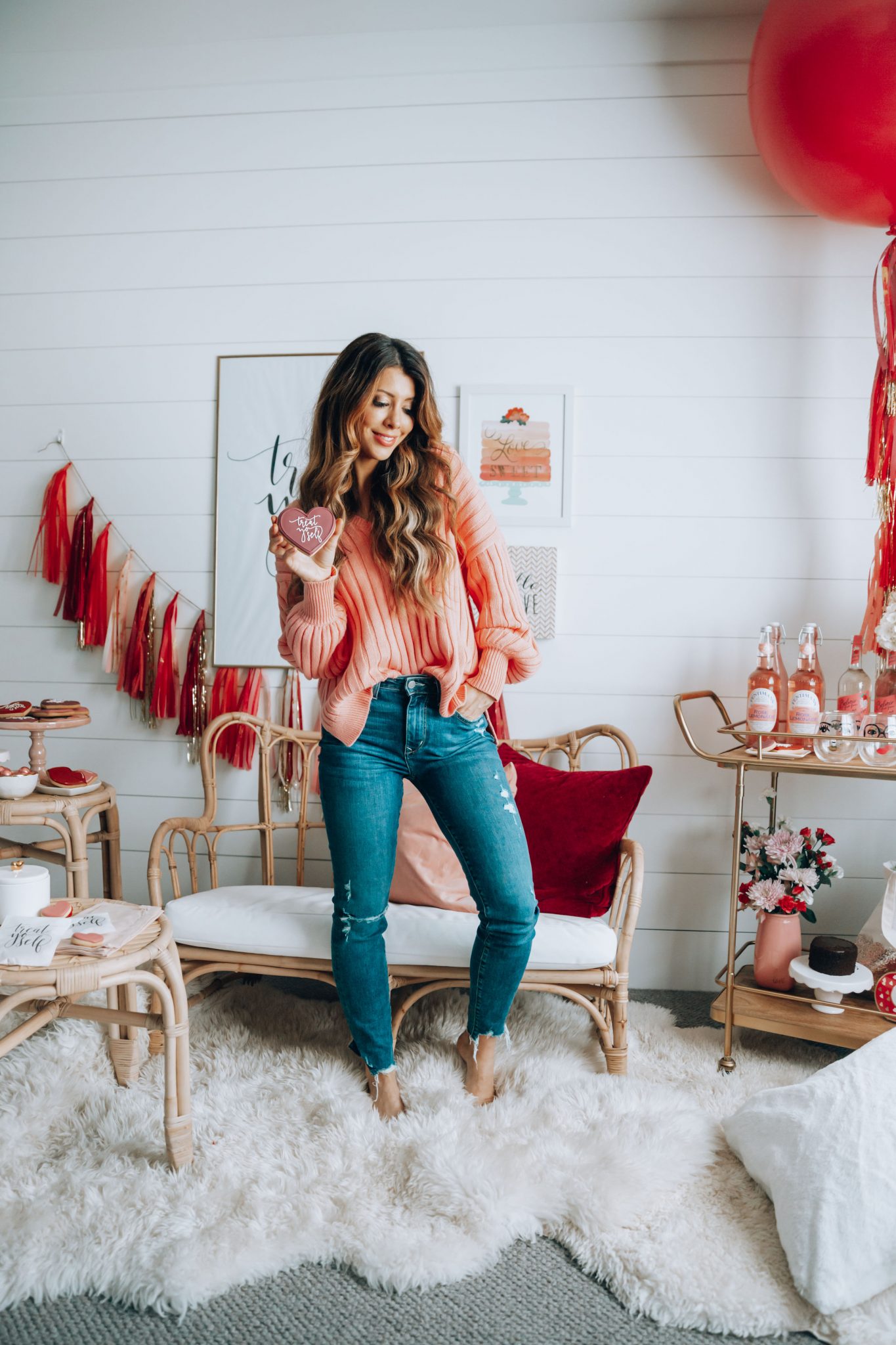 Galentines featured by top US life and style blog The Girl in the Yellow Dress; Image of a woman wearing a pink sweater and jeans.