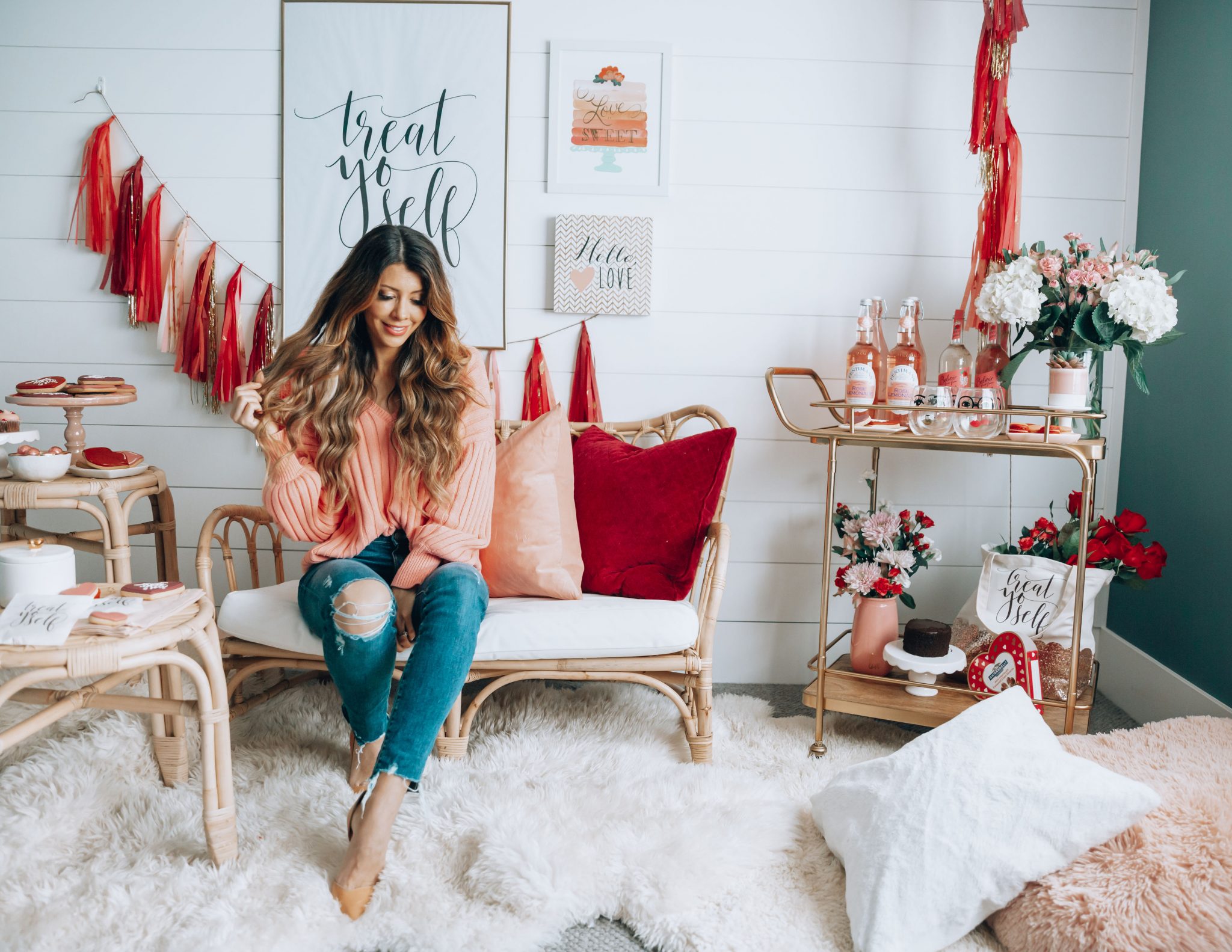 Galentines featured by top US life and style blog The Girl in the Yellow Dress; Image of a woman wearing a pink sweater and jeans.