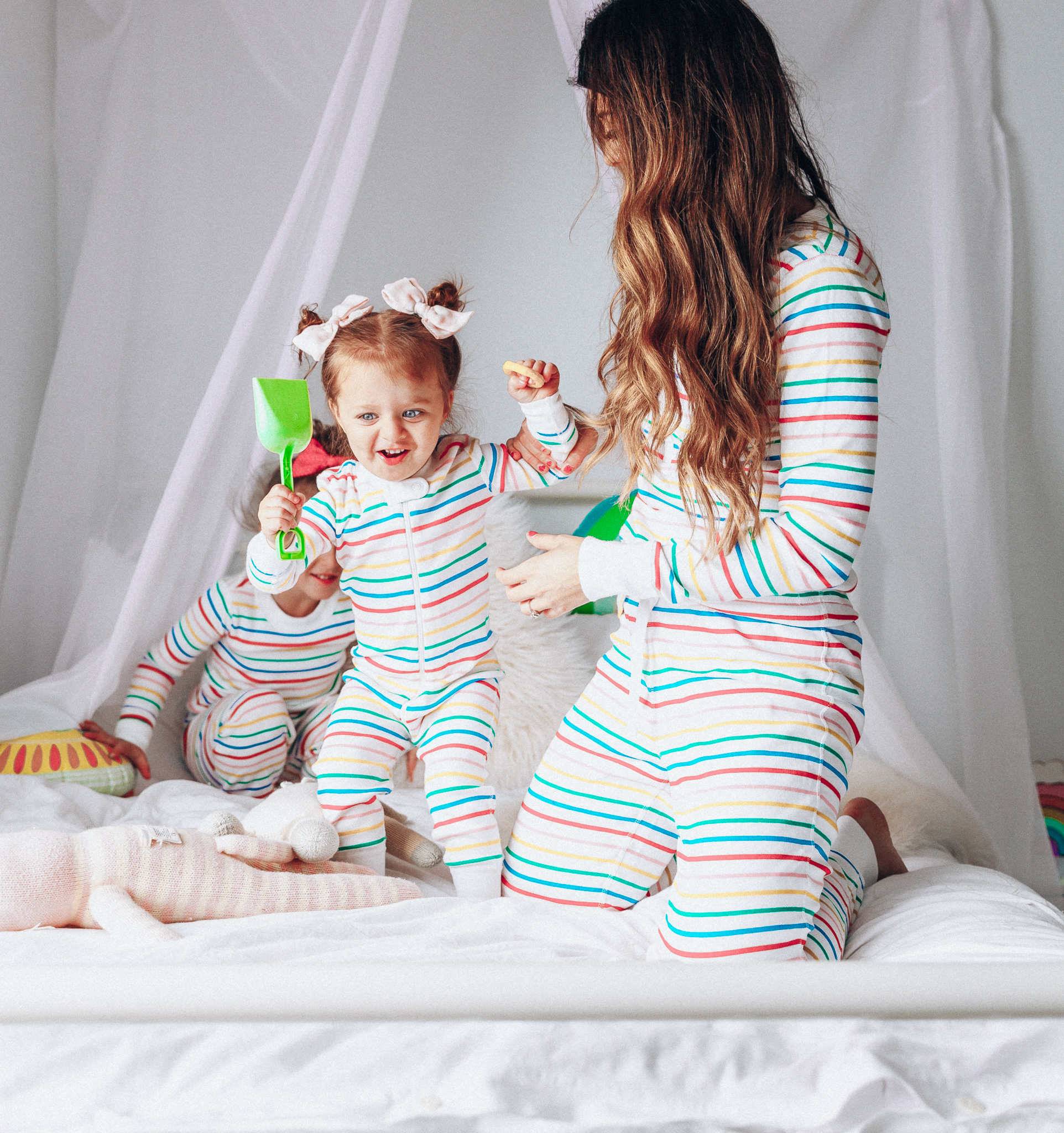 Matching Family Pajamas featured by top US life and style blog The Girl in the Yellow Dress; Image of a family wearing matching rainbow Hanna Andersson pajamas.