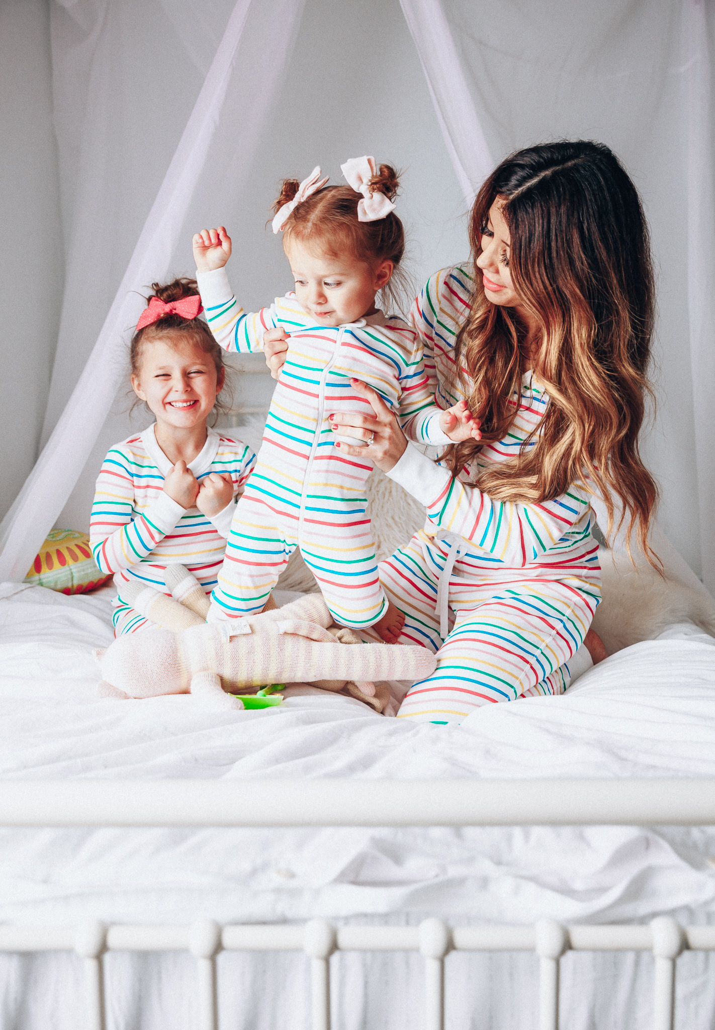 Matching Family Pajamas featured by top US life and style blog The Girl in the Yellow Dress; Image of a family wearing matching rainbow Hanna Andersson pajamas.