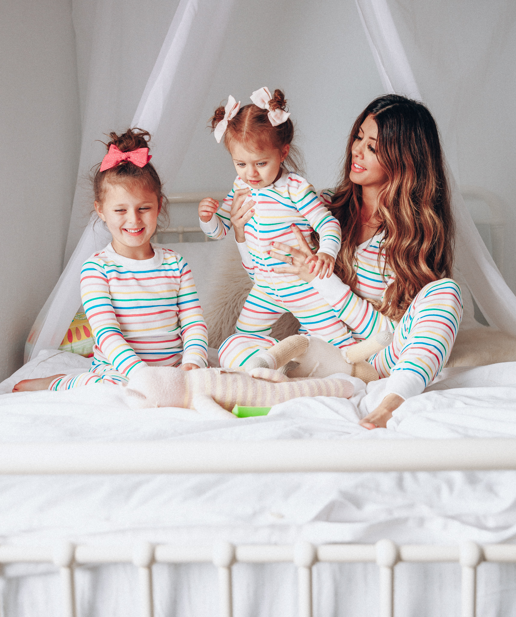 Matching Family Pajamas featured by top US life and style blog The Girl in the Yellow Dress; Image of a family wearing matching rainbow Hanna Andersson pajamas.