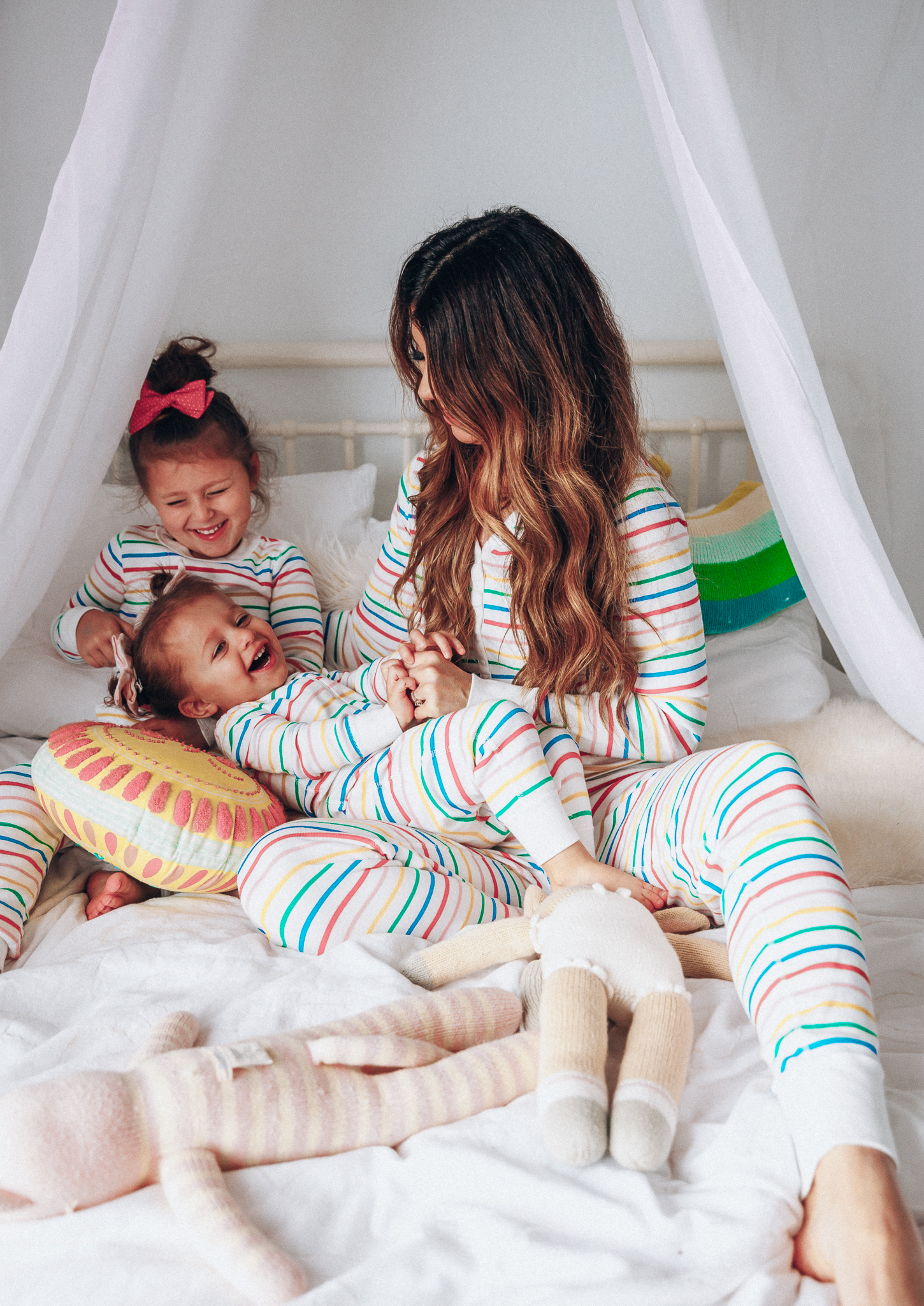 Matching Family Pajamas featured by top US life and style blog The Girl in the Yellow Dress; Image of a family wearing matching rainbow Hanna Andersson pajamas.