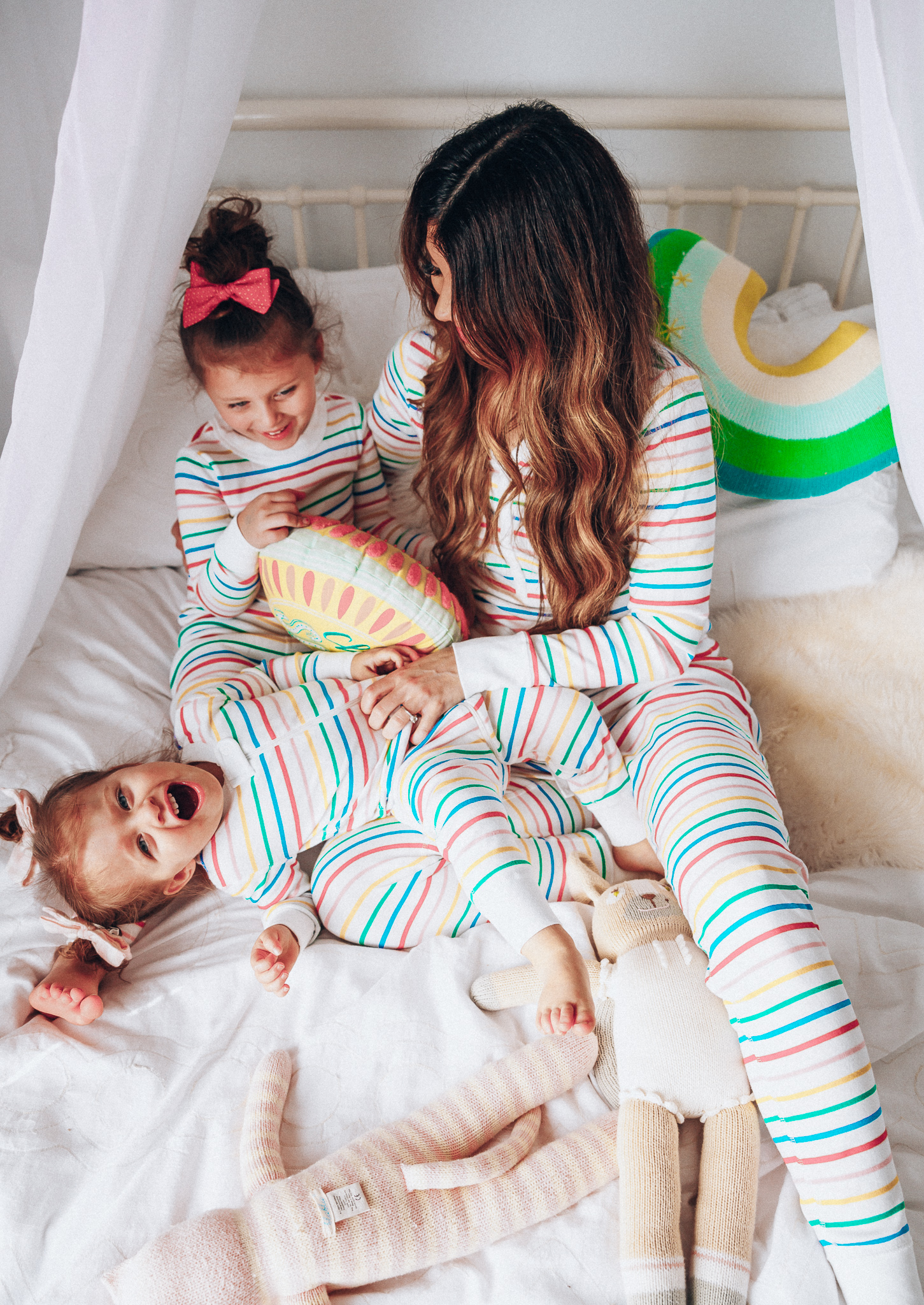 Matching Family Pajamas featured by top US life and style blog The Girl in the Yellow Dress; Image of a family wearing matching rainbow Hanna Andersson pajamas.