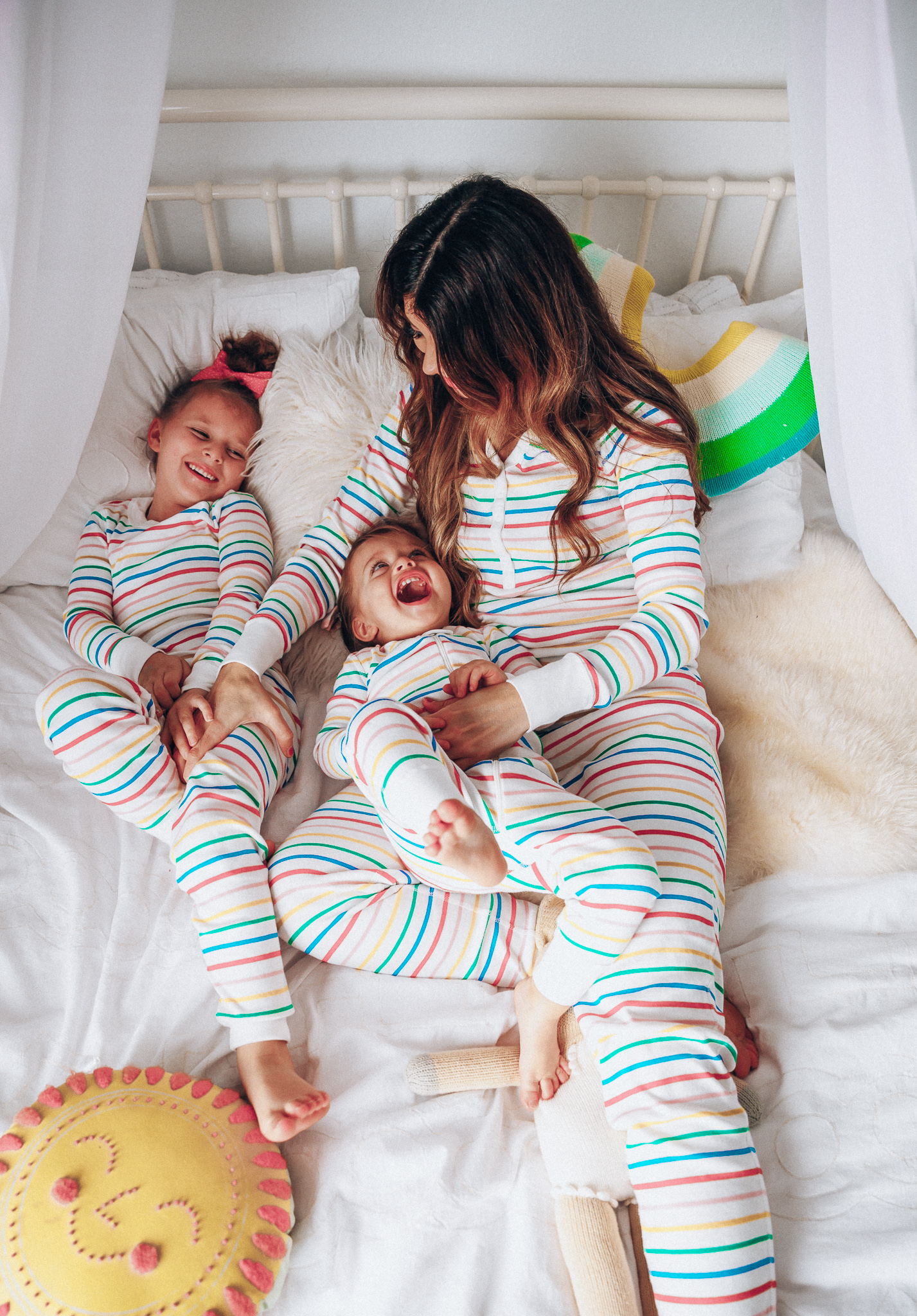 Matching Family Pajamas featured by top US life and style blog The Girl in the Yellow Dress; Image of a family wearing matching rainbow Hanna Andersson pajamas.