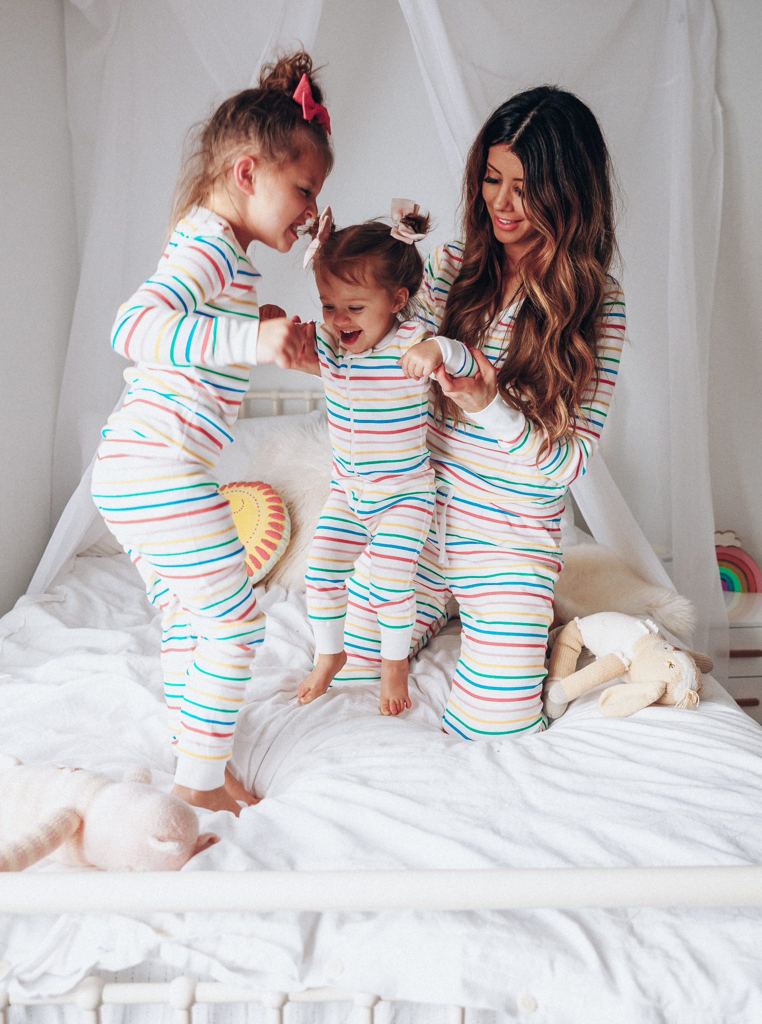 Matching Family Pajamas featured by top US life and style blog The Girl in the Yellow Dress; Image of a family wearing matching rainbow Hanna Andersson pajamas.