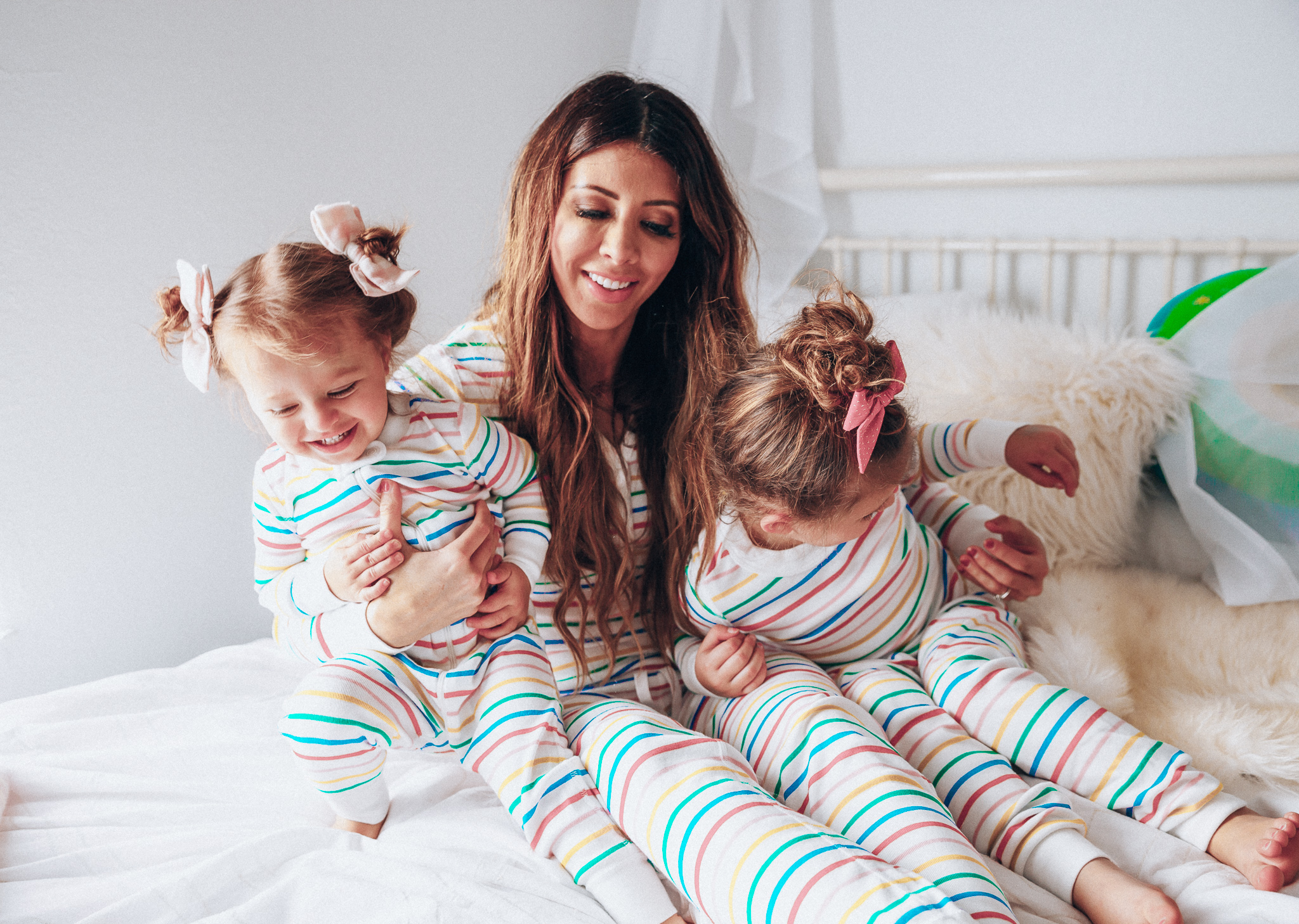 Matching Family Pajamas featured by top US life and style blog The Girl in the Yellow Dress; Image of a family wearing matching rainbow Hanna Andersson pajamas.