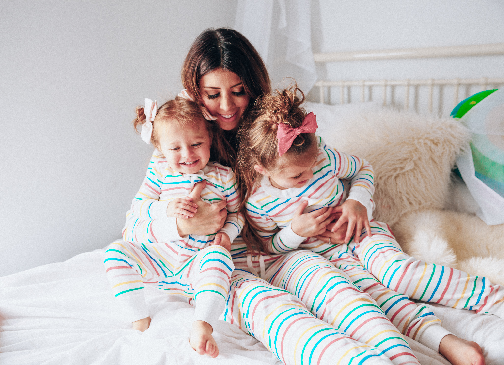 Matching Family Pajamas featured by top US life and style blog The Girl in the Yellow Dress; Image of a family wearing matching rainbow Hanna Andersson pajamas.