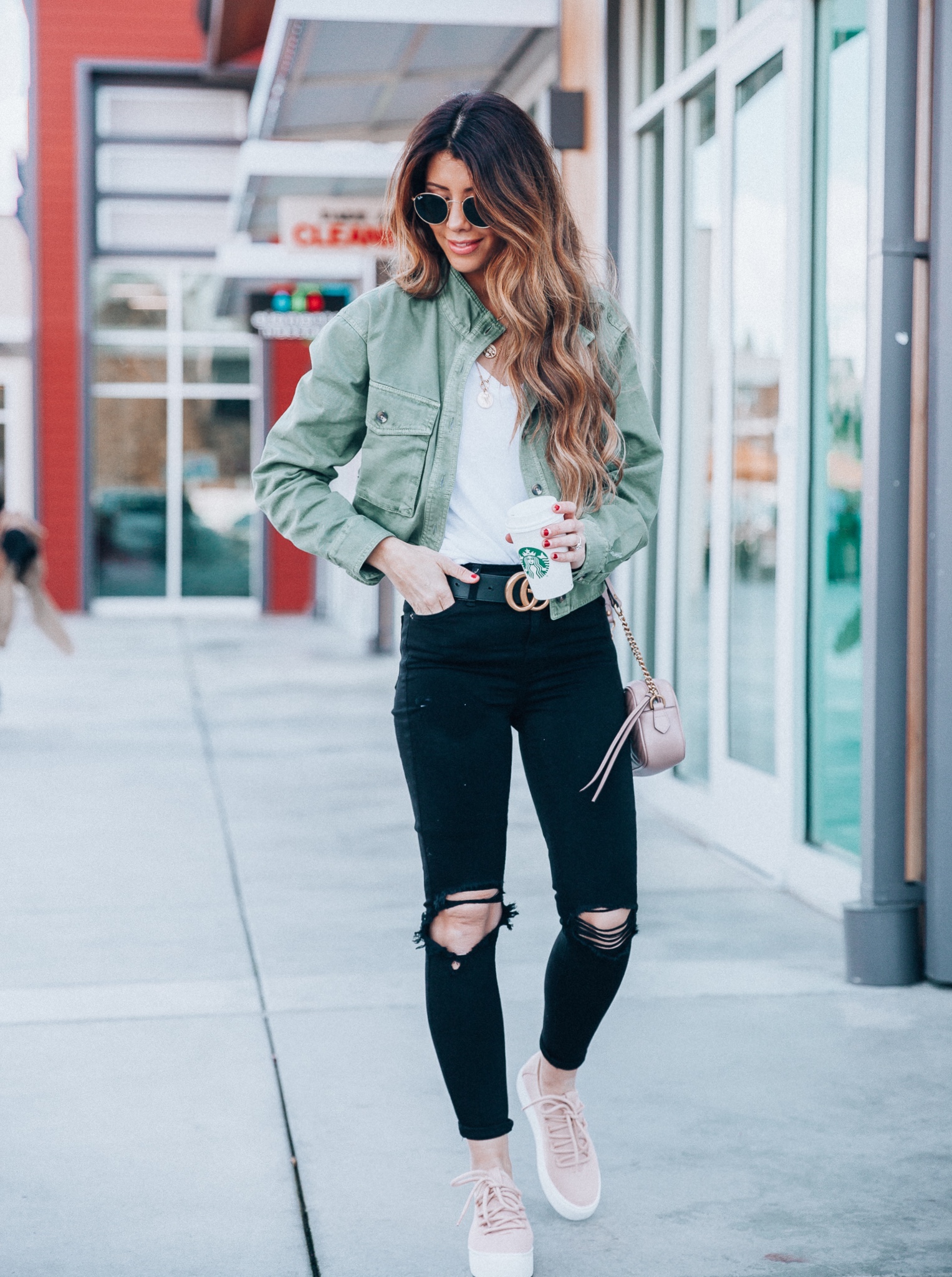 Summer Trends featured by top US fashion blog The Girl in the Yellow Dress; Image of a woman wearing platform shoes, black denim, Gucci belt and green jacket.