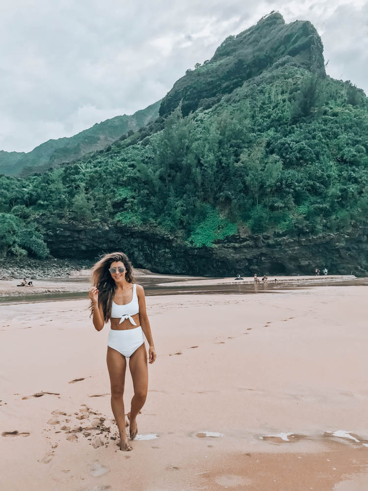 Beach Getaway featured by top US life and style blog The Girl in the Yellow Dress; Image of a woman at the beach wearing an ASOS swimsuit and Ray-Ban sunglasses.