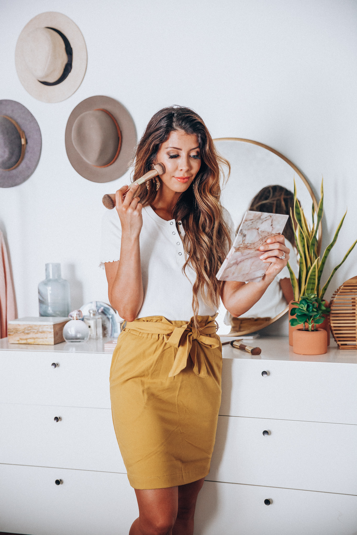 Maskcara Makeup featured by top US beauty blog The Girl in the Yellow Dress; Image of a woman wearing an American Eagle white tee and mustard skirt from H&M.