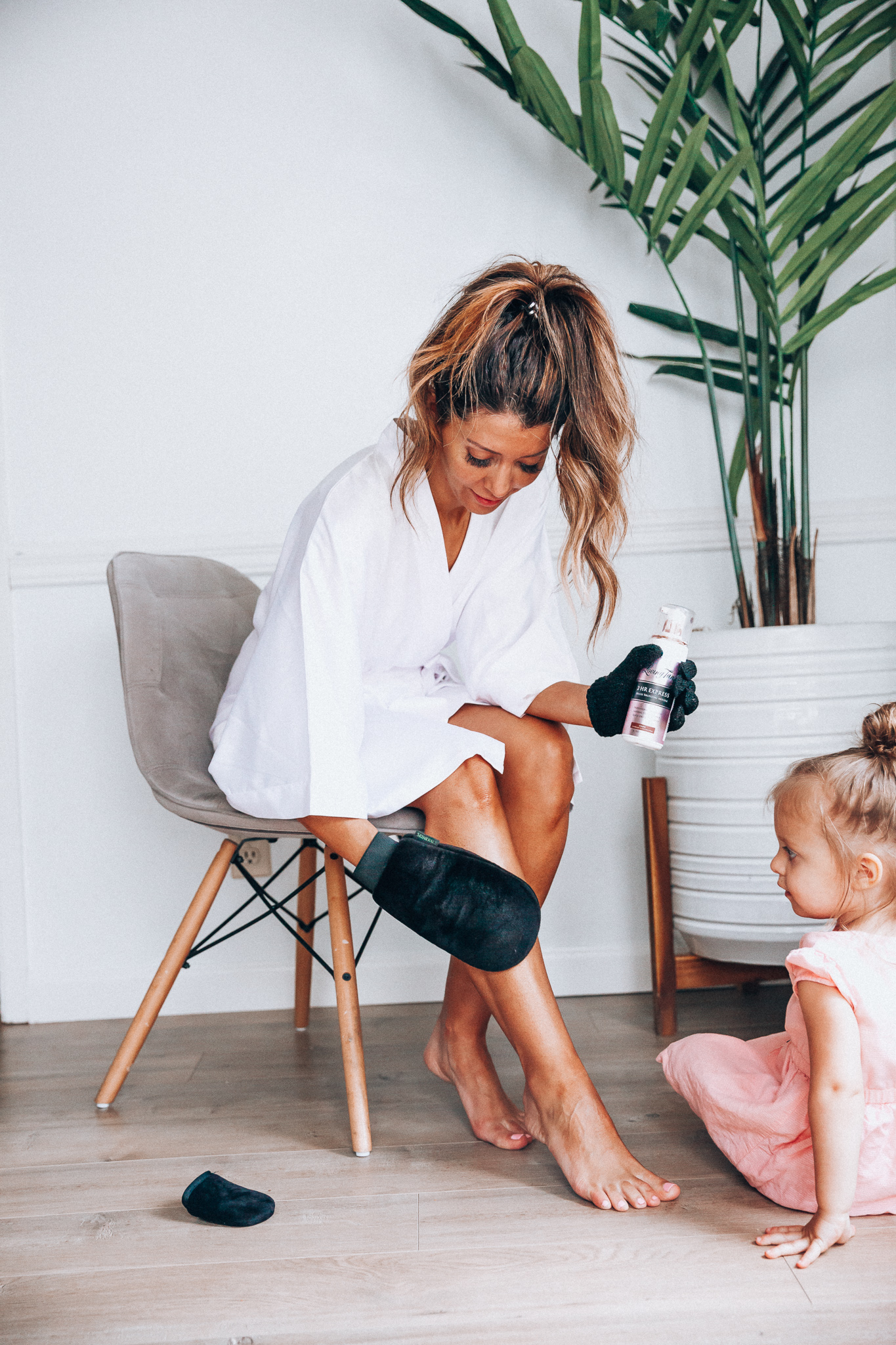 Self Tanning Tips featured by top US beauty blog The Girl in the Yellow Dress; Image of a woman applying self tanner.