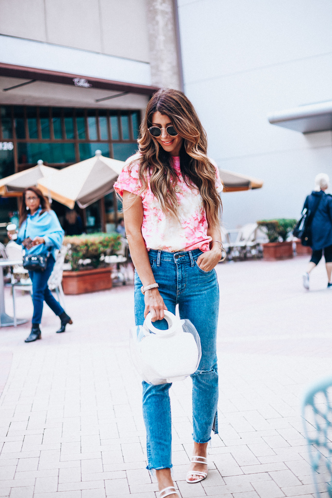 Summer Trends featured by top US fashion blog The Girl in the Yellow Dress; Image of a woman wearing Nordstrom shirt, Levi's, Staud bag, Steven sandals and Ray-Ban sunglasses.