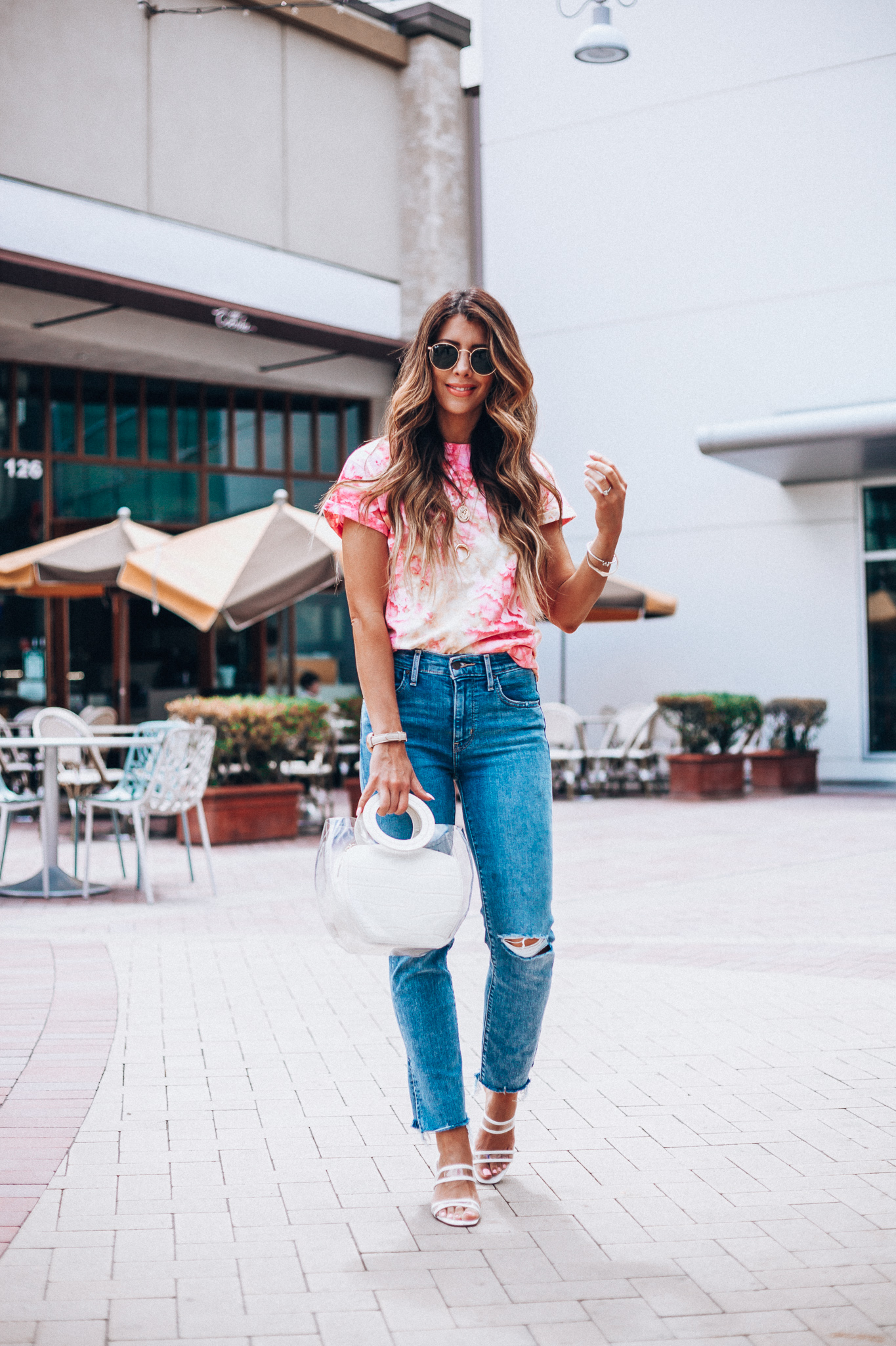 Summer Trends featured by top US fashion blog The Girl in the Yellow Dress; Image of a woman wearing Nordstrom shirt, Levi's, Staud bag, Steven sandals and Ray-Ban sunglasses.