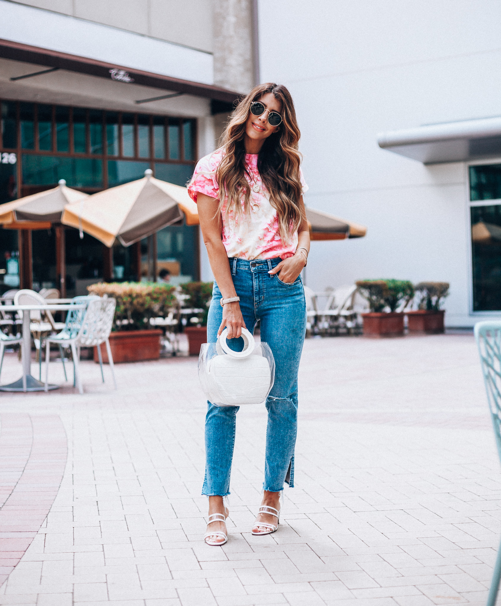 Summer Trends featured by top US fashion blog The Girl in the Yellow Dress; Image of a woman wearing Nordstrom shirt, Levi's, Staud bag, Steven sandals and Ray-Ban sunglasses.