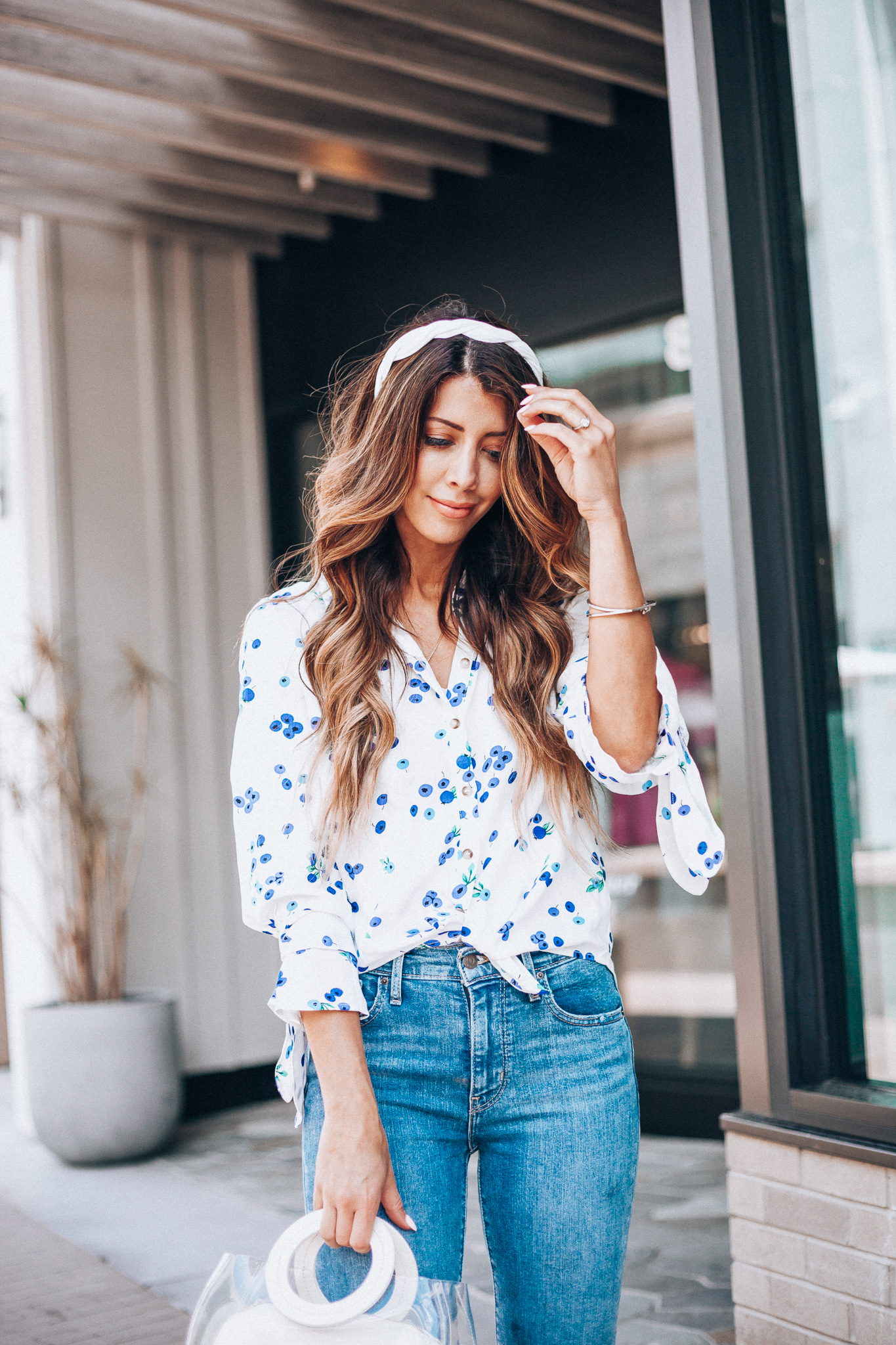 Cute Summer Tops You'll Love by popular US fashion blog, The Girl in the Yellow Dress: image of woman outside wearing an Anthropologie Blithe Button down top, shopbop levi's 724 high rise straight crop jeans, white Anthropologie Ara Knot headband, and holding a shopbop frida bag.