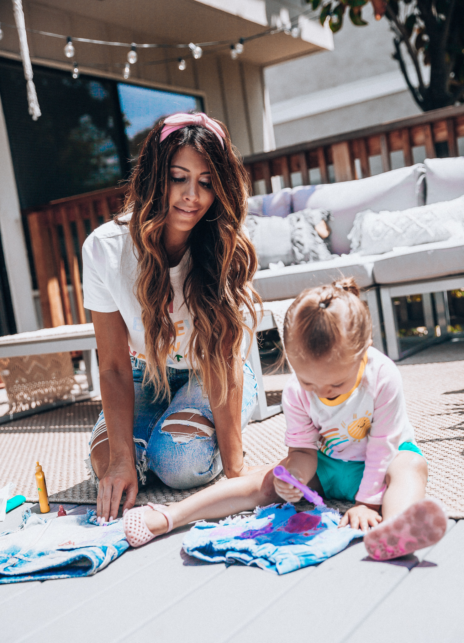 The Girl in the Yellow Dress | Latisha Springer | Fun Summer Activities for Kids by top US mom blog, The Girl in the Yellow Dress: image of mom with young girl sitting on back porch decorating cutoff denim shorts with puff paint.