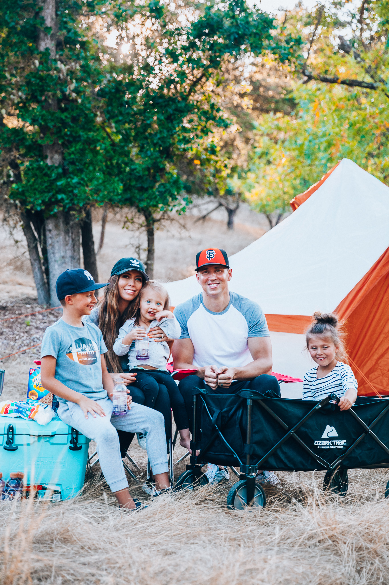 Ozark Trail with Walmart by popular San Francisco life and style blog, The Girl in the Yellow Dress: image of a family outside camping with an Ozark Trail, 8 Person Yurt Camping Tent, Ozark Trail Folding Multipurpose Wagon, Ozark Trail Oversize Mesh Folding Camping Chair, Ozark Trail 26-Quart High-Performance Cooler, Ozark Trail 30-Ounce Double-Wall, Vacuum-Sealed Tumbler, and Ozark Trail Outdoor Equipment 400 Lumen LED Camping Lantern from Walmart.