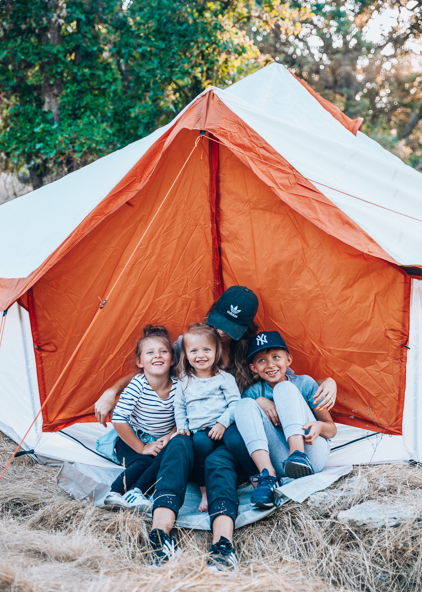 Ozark Trail with Walmart by popular San Francisco life and style blog, The Girl in the Yellow Dress: image of a mom and her three kids sitting in an Ozark Trail, 8 Person Yurt Camping Tent from Walmart.