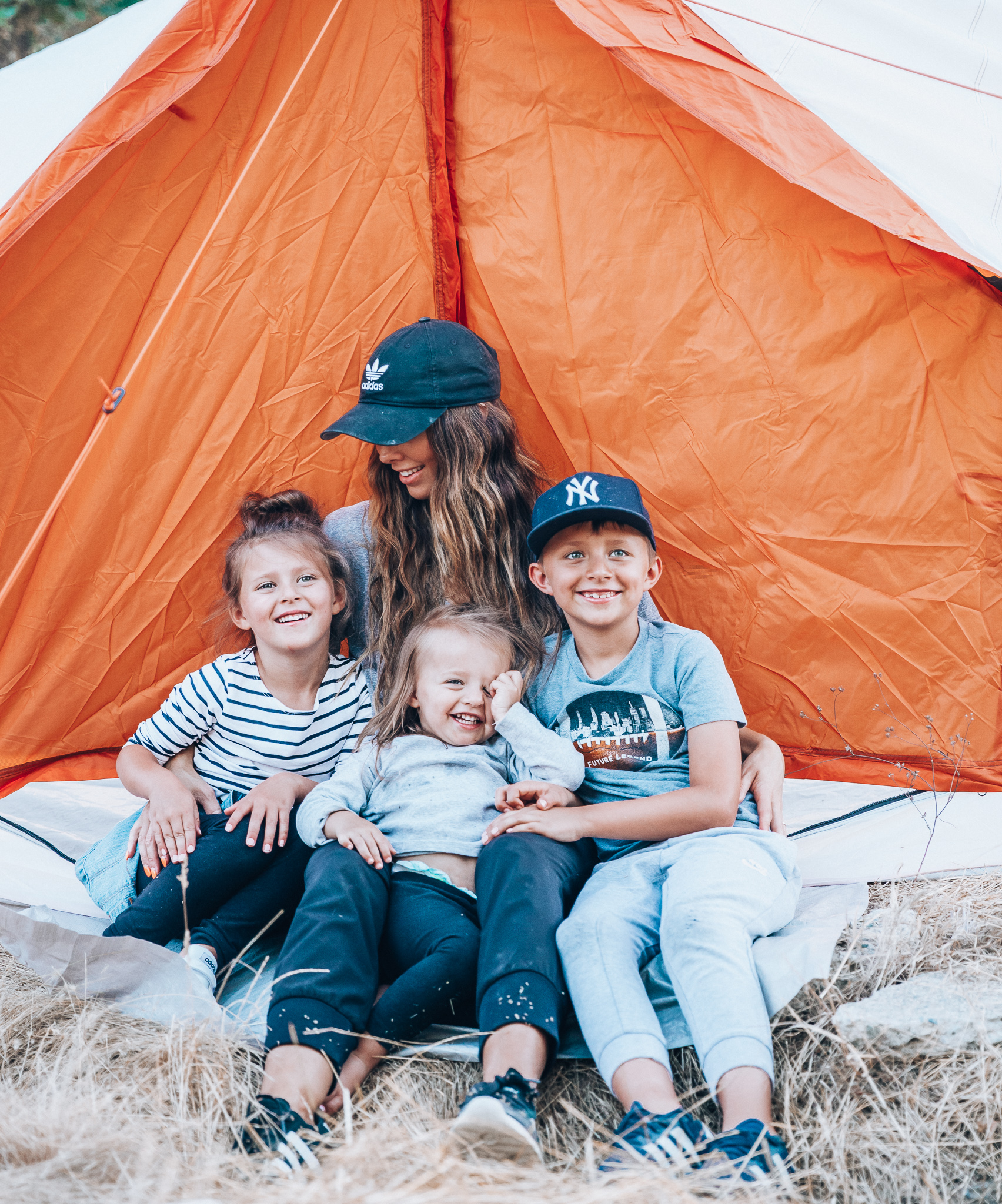 Ozark Trail with Walmart by popular San Francisco life and style blog, The Girl in the Yellow Dress: image of a mom and her three kids sitting in an Ozark Trail, 8 Person Yurt Camping Tent from Walmart.