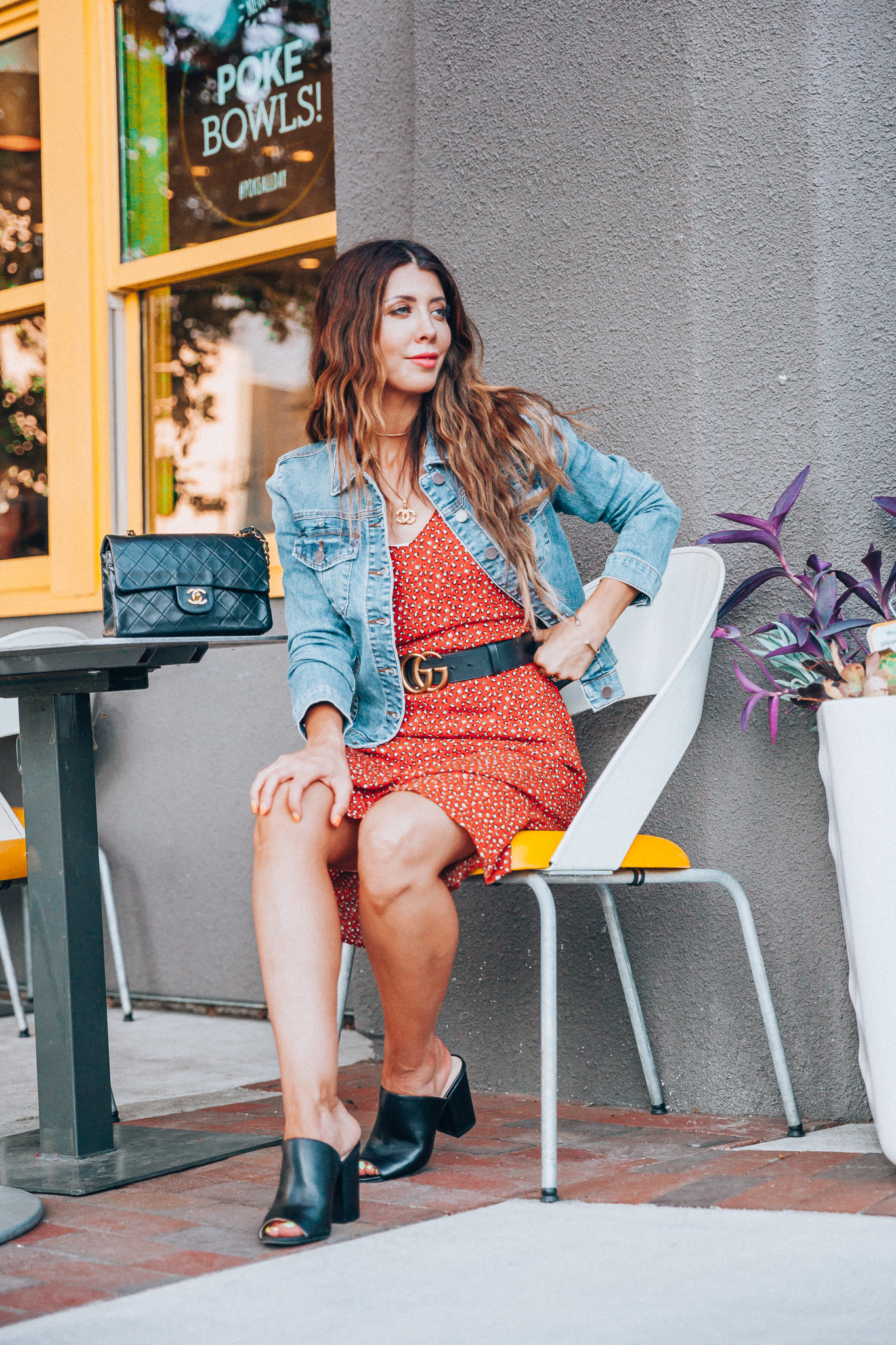 My Top Summer eBay Finds! by popular San Francisco life and style blog, The Girl in the Yellow Dress: image of a woman sitting outside and wearing a orange eBay leopard print dress, trucker Levis Strauss & Co denim Jacket, Women's Didi Block Heel Mules, Chanel Matelasse Double Flap Double Chain Bag, CHANEL CC Logo Pendant Necklace Gold Vintage 17.7inch, and Authentic Women Gucci Double GG Buckle Belt Size 85cm 1 inch width from eBay.