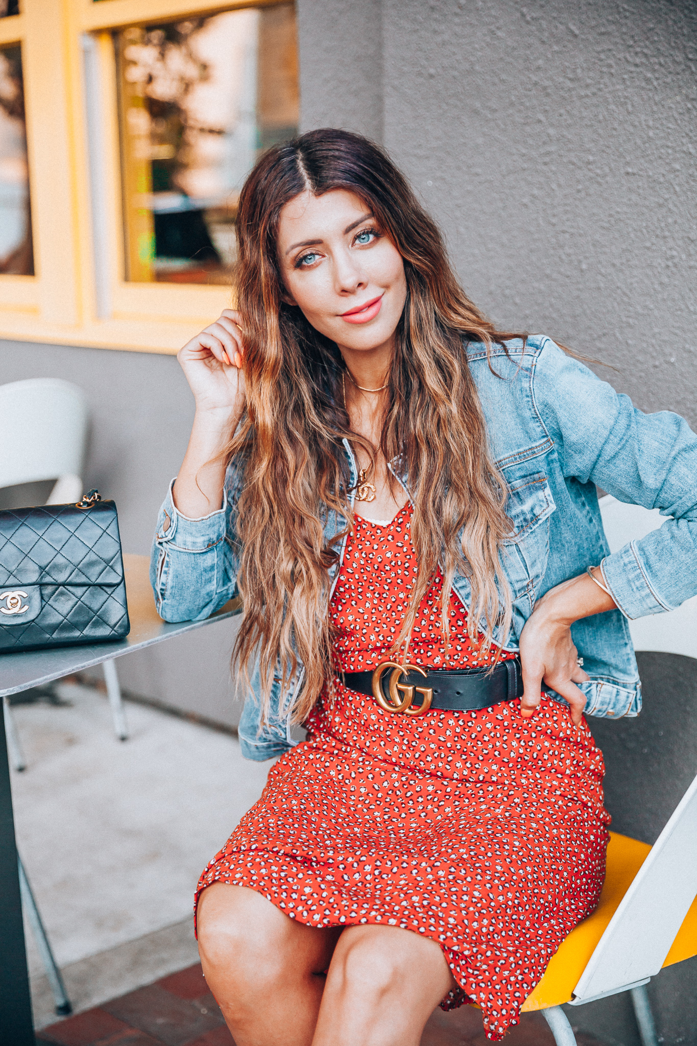 My Top Summer eBay Finds! by popular San Francisco life and style blog, The Girl in the Yellow Dress: image of a woman sitting outside and wearing a orange eBay leopard print dress, trucker Levis Strauss & Co denim Jacket, Women's Didi Block Heel Mules, Chanel Matelasse Double Flap Double Chain Bag, CHANEL CC Logo Pendant Necklace Gold Vintage 17.7inch, and Authentic Women Gucci Double GG Buckle Belt Size 85cm 1 inch width from eBay.