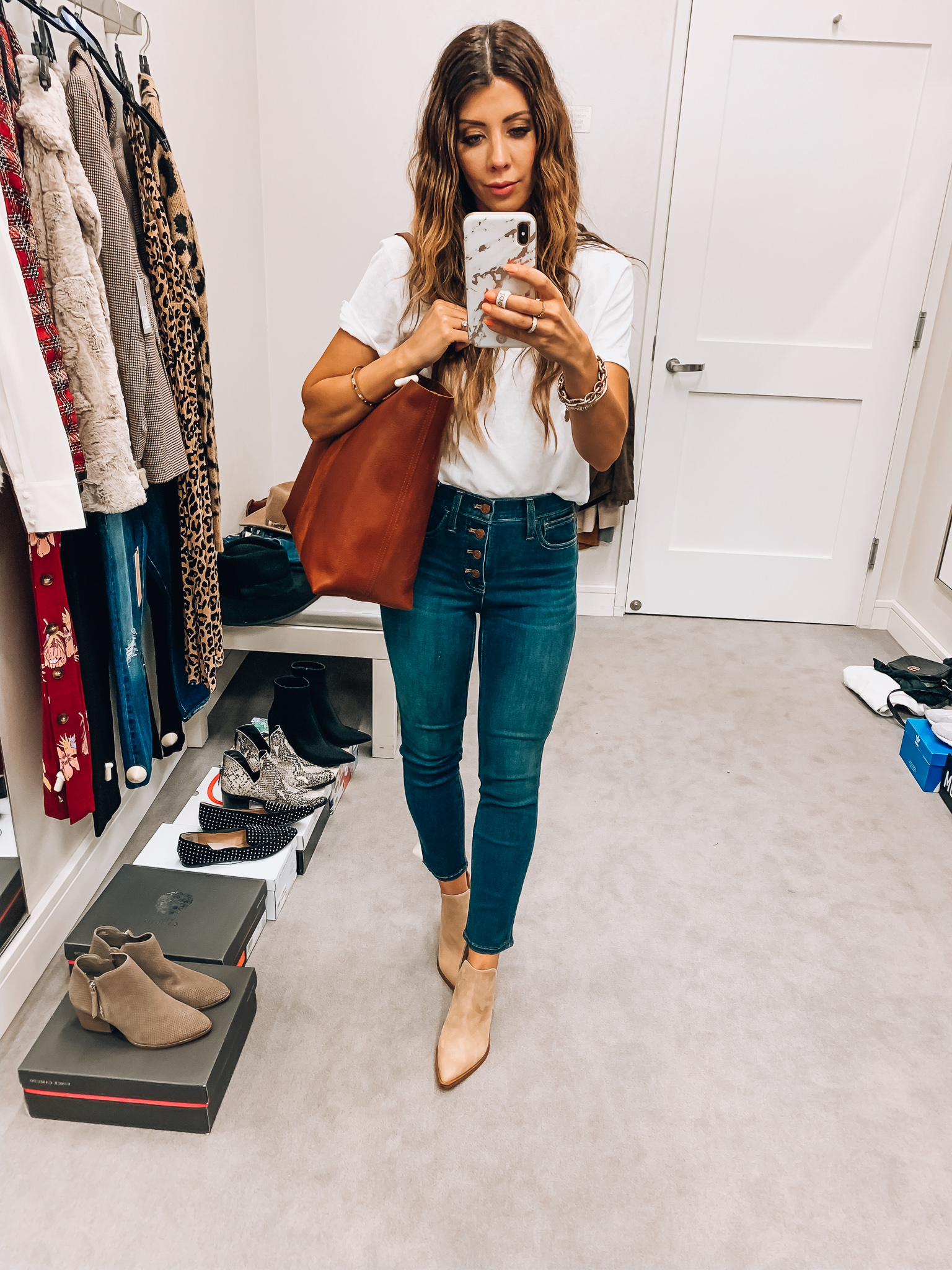 Nordstrom Anniversary Sale Early Access! by popular San Francisco fashion blog, The Girl in the Yellow Dress: image of a woman standing inside a Nordstrom dressing room wearing Madewell 10-Inch High Waist Skinny Jeans: Button Front Edition, BP. V-Neck Tee, Vince Camuto Gigietta Bootie, and Small Transport Leather Crossbody Tote. 