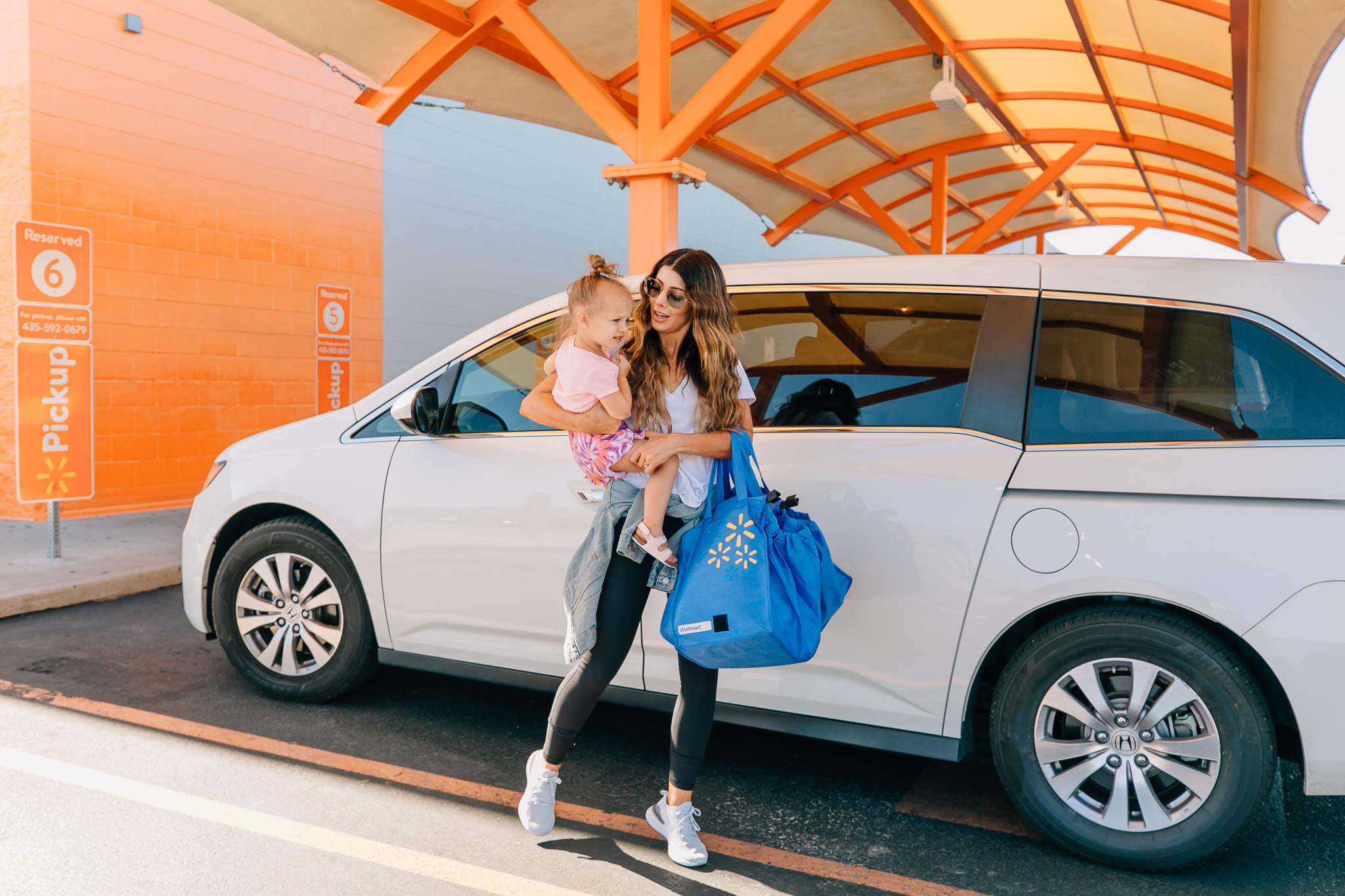 Walmart Grocery Pick Up Review! by popular San Francisco lifestyle blog, The Girl in the Yellow Dress: image of a mom holding her daughter outside in front of the Walmart grocery pick-up.