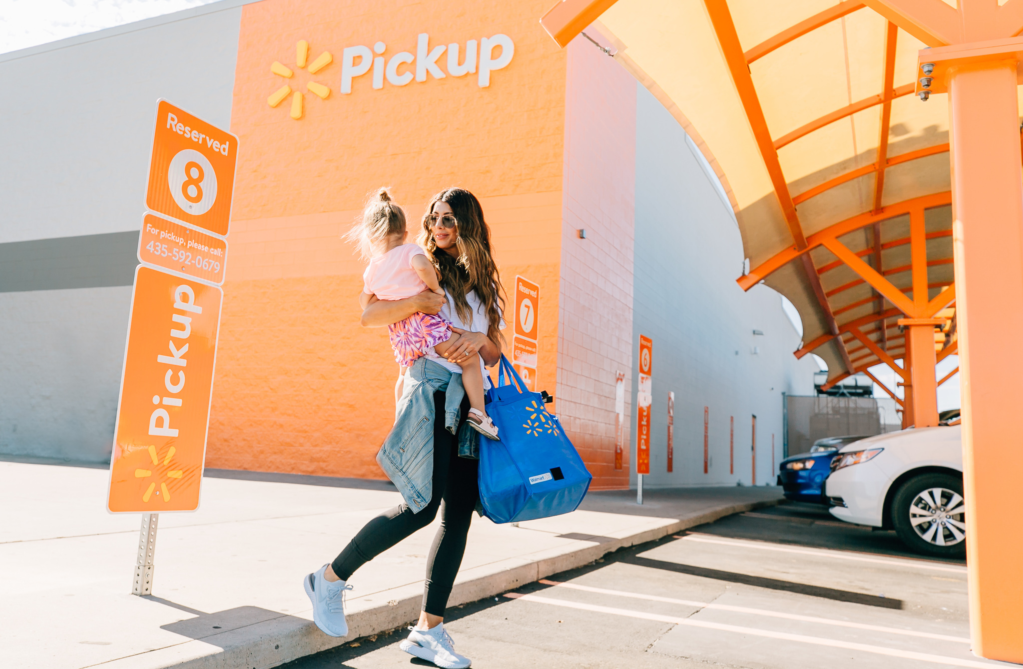 Walmart Grocery Pick Up Review! by popular San Francisco lifestyle blog, The Girl in the Yellow Dress: image of a mom holding her daughter outside in front of the Walmart grocery pick-up.