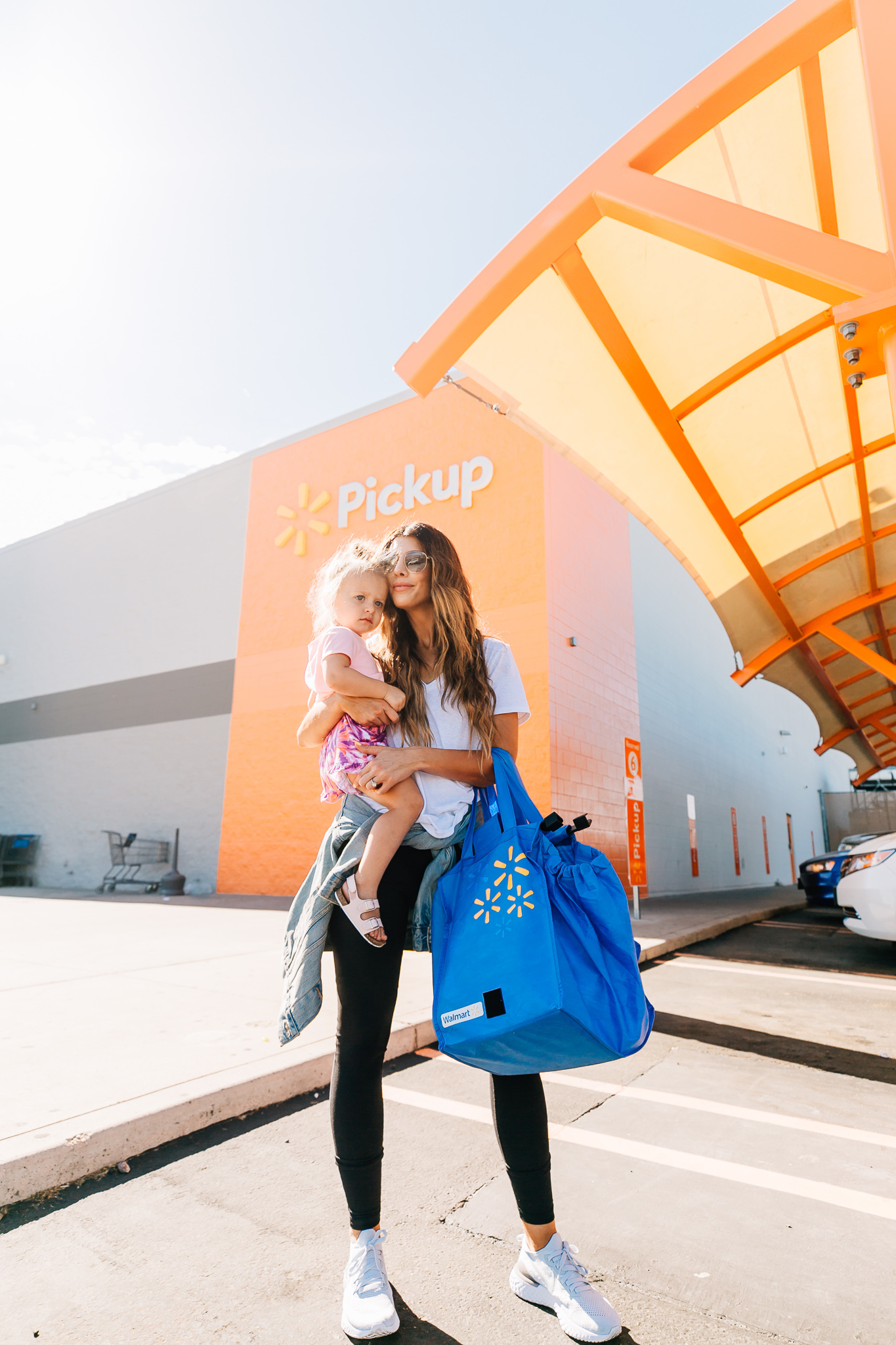 Walmart Grocery Pick Up Review! by popular San Francisco lifestyle blog, The Girl in the Yellow Dress: image of a mom holding her daughter outside in front of the Walmart grocery pick-up.