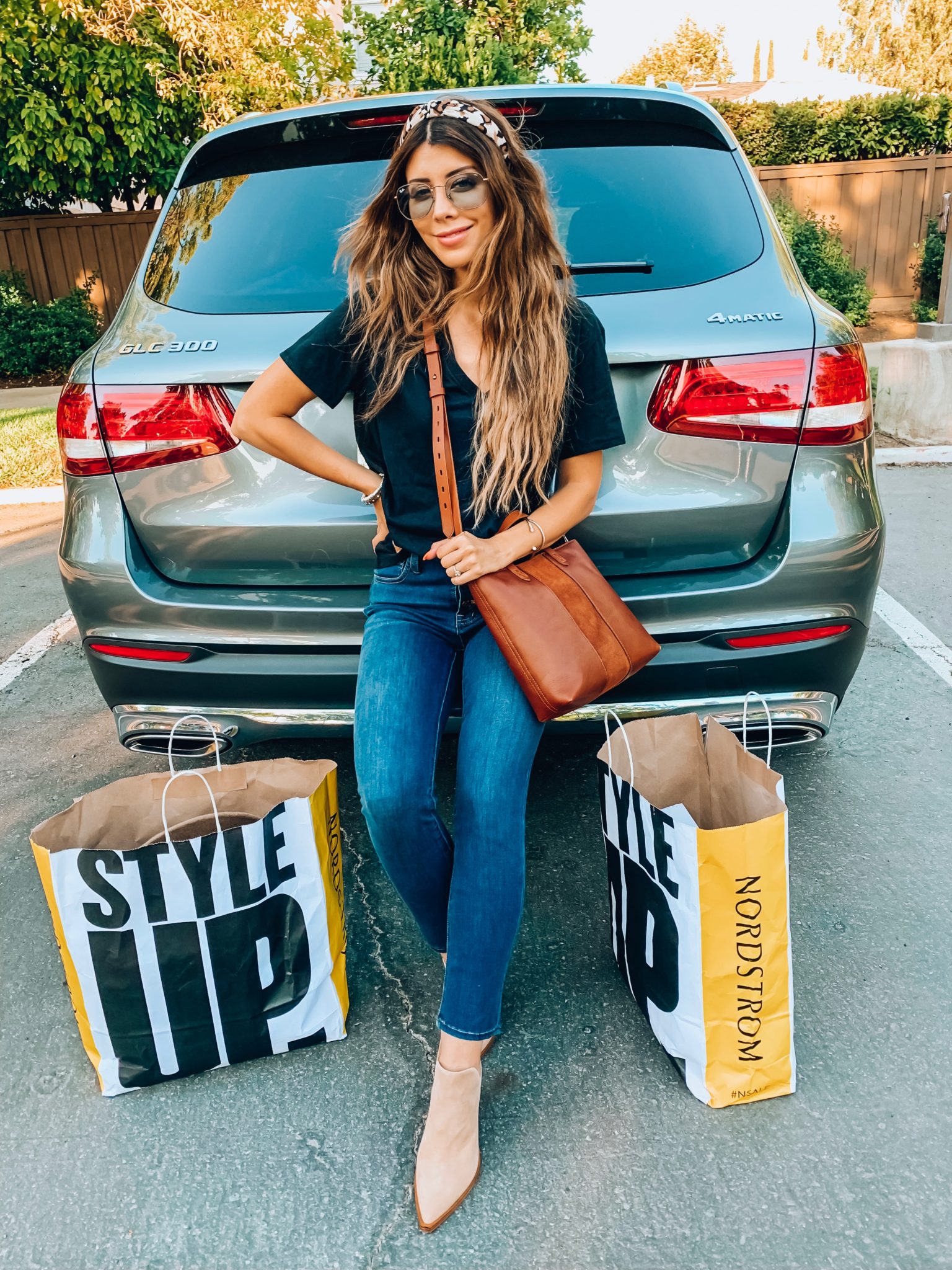 Last Chance to Shop the Nordstrom Anniversary Sale! by popular San Francisco fashion blog, The Girl in the Yellow Dress: image of a woman leaning against her car with two Nordstrom Anniversary Sale shopping bags by her feet.