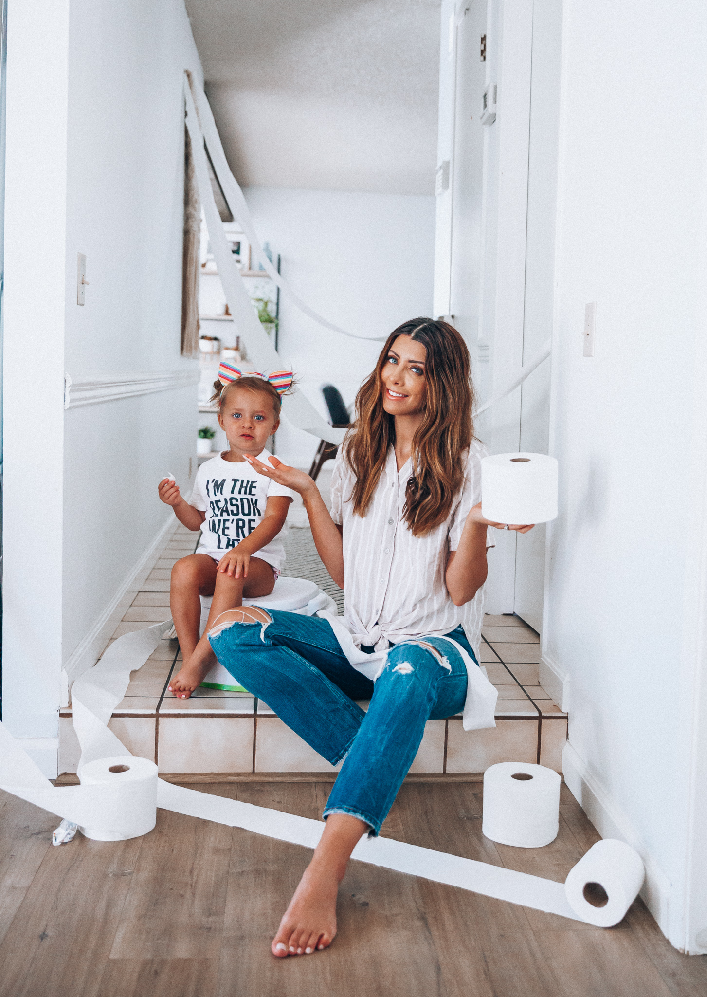 Our Potty Training Tips + Journey by popular San Francisco lifestyle blog, The Girl in the Yellow Dress: image of a woman and her daughter sitting on the ground with some toilet paper and a potty training toilet.