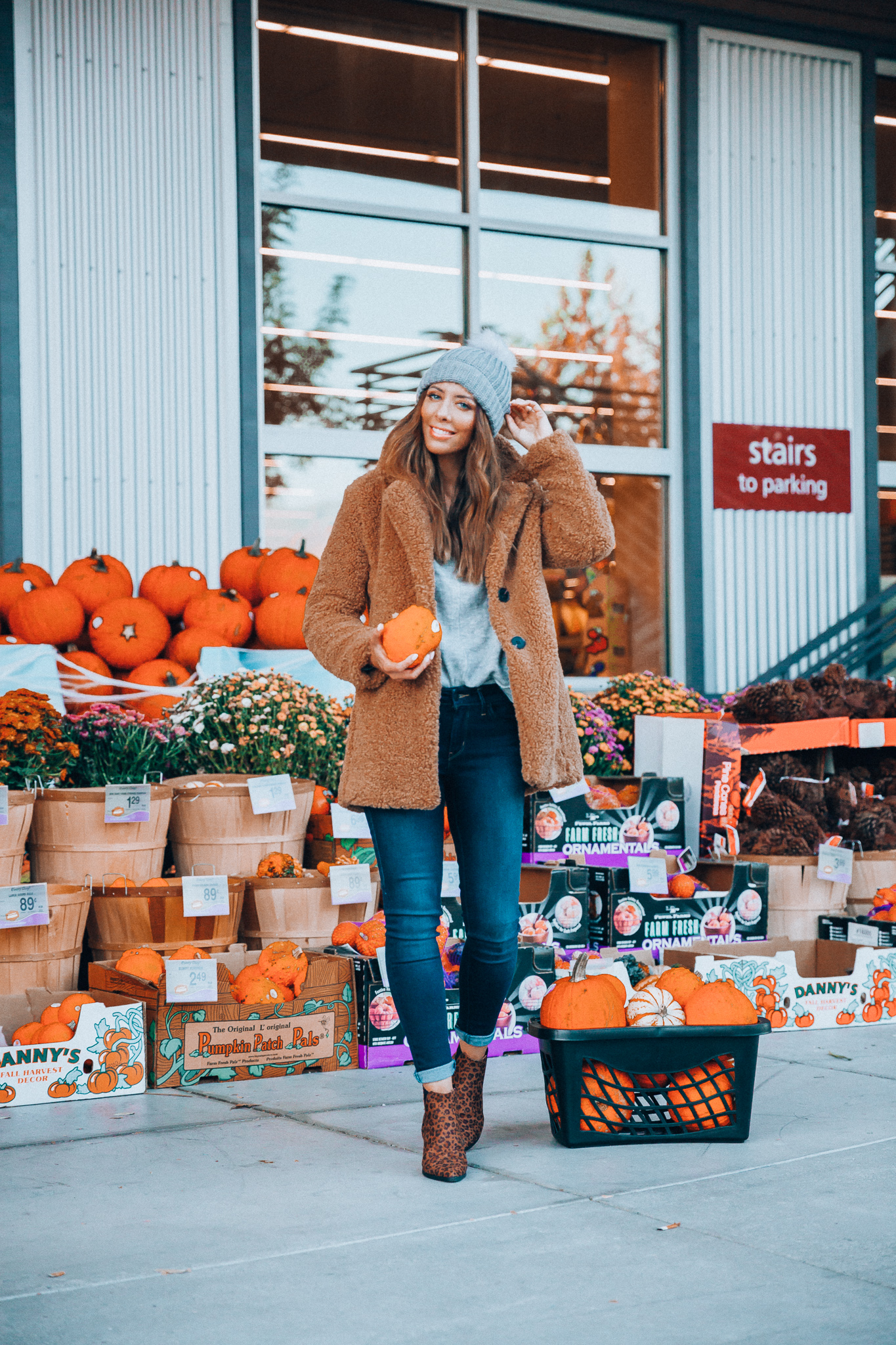 The Best Weekend Sales by popular San Francisco fashion blog, The Girl in the Yellow Dress: image of a woman standing in front of a pumpkin display and wearing a JCPenney Liz Claiborne Sherpa Lightweight Faux Fur Coat, JCPenney Mixit Beanie, JCPenney Levi's® 711™ Skinny Jeans, JCPenney a.n.a Womens Garwin Block Heel Elastic Booties, and JCPenney a.n.a Womens V Neck Long Sleeve Pullover Sweater.