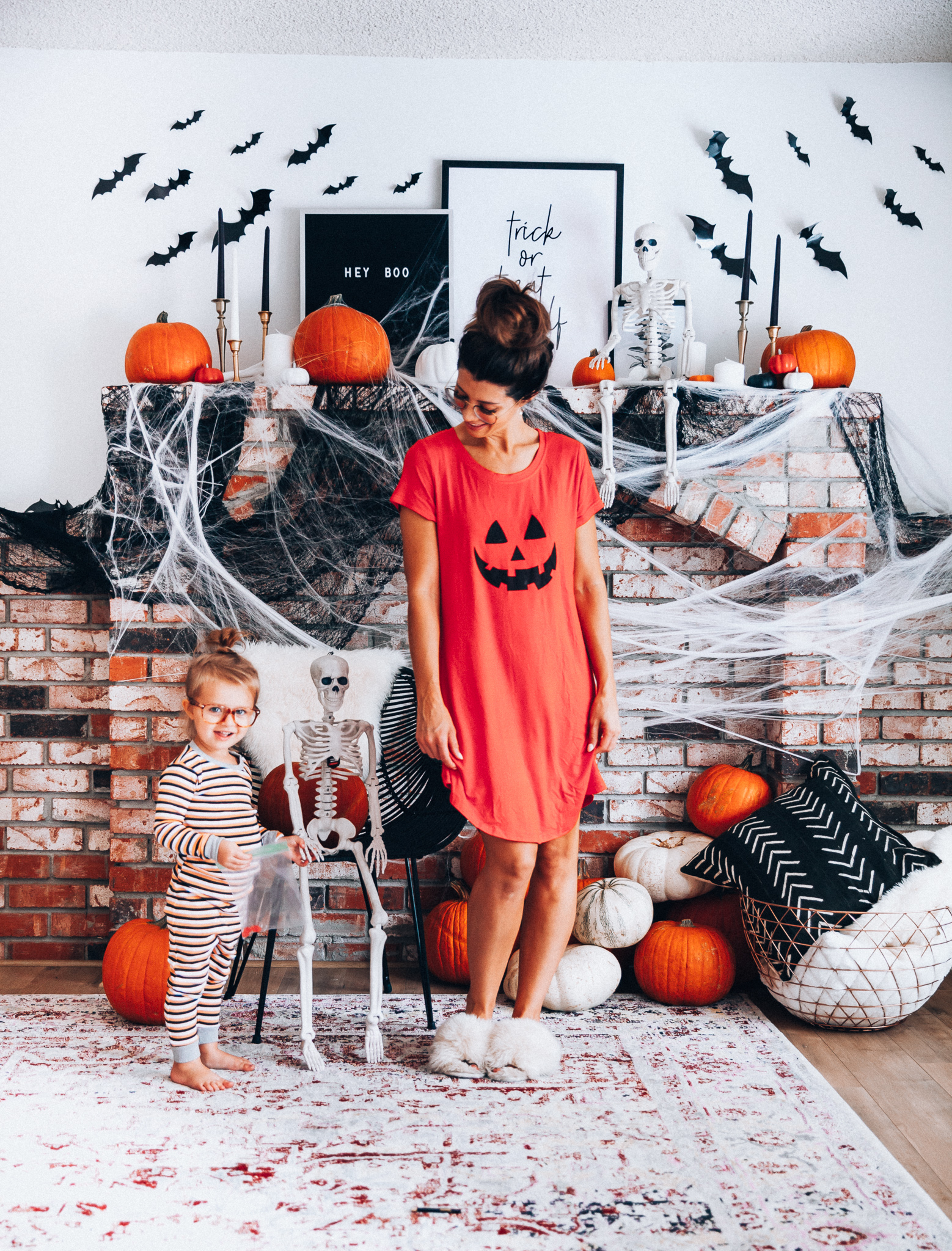 Halloween Mantel Decor + FREE Halloween Printable! by popular San Francisco lifestyle blog, The Girl in the Yellow Dress: image of woman and her young daughter sitting in front a their mantel decorated with Target Halloween decor and Amazon 3D bats and wearing Amazon Burt's Bees Baby Baby Pajamas, Tee and Pant 2-Piece PJ Set, Amazon Seekingtag Children Stylish Cute Glasses Frame Without Lenses, Amazon Hotouch Sleepwear Women's Nightgown Cotton Sleep Shirt, Eye Buy Direct FORTUNE Rectangle Tortoise Eyeglasses, and Nordstrom Patricia Green Mt. Hood Genuine Shearling Slipper.