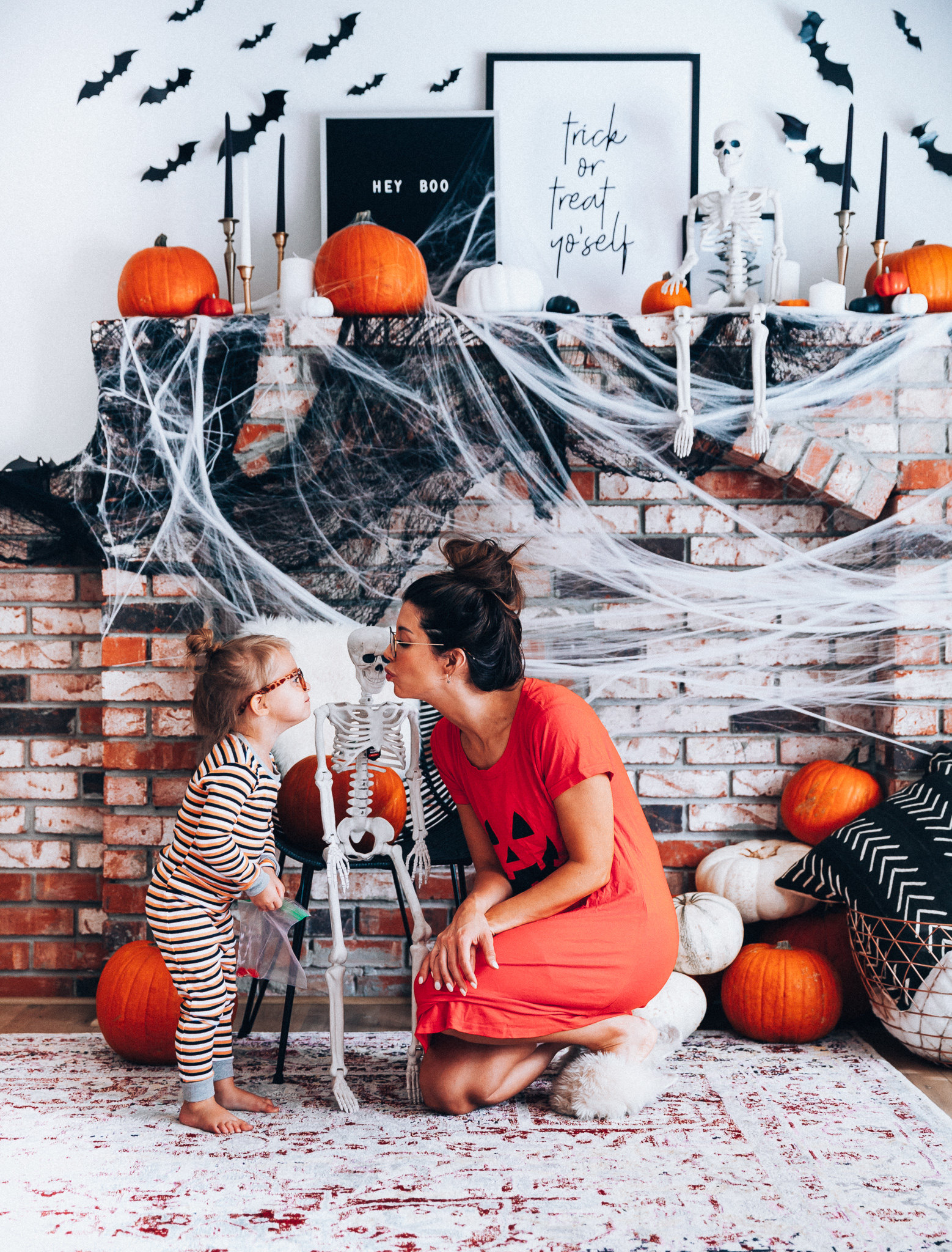 Halloween Mantel Decor + FREE Halloween Printable! by popular San Francisco lifestyle blog, The Girl in the Yellow Dress: image of woman and her young daughter sitting in front a their mantel decorated with Target Halloween decor and Amazon 3D bats and wearing Amazon Burt's Bees Baby Baby Pajamas, Tee and Pant 2-Piece PJ Set, Amazon Seekingtag Children Stylish Cute Glasses Frame Without Lenses, Amazon Hotouch Sleepwear Women's Nightgown Cotton Sleep Shirt, Eye Buy Direct FORTUNE Rectangle Tortoise Eyeglasses, and Nordstrom Patricia Green Mt. Hood Genuine Shearling Slipper.