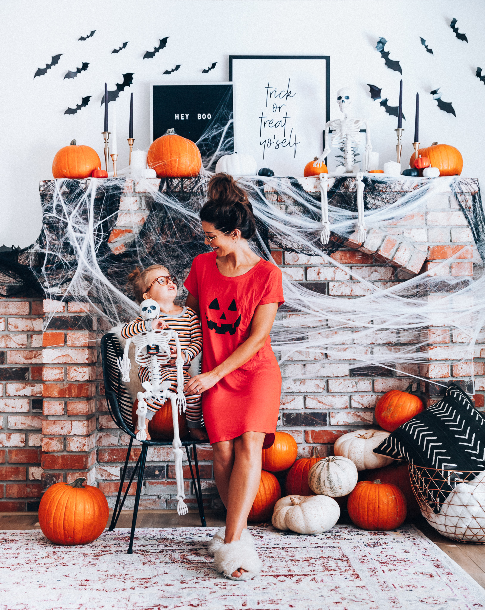 Halloween Mantel Decor + FREE Halloween Printable! by popular San Francisco lifestyle blog, The Girl in the Yellow Dress: image of woman and her young daughter sitting in front a their mantel decorated with Target Halloween decor and Amazon 3D bats and wearing Amazon Burt's Bees Baby Baby Pajamas, Tee and Pant 2-Piece PJ Set, Amazon Seekingtag Children Stylish Cute Glasses Frame Without Lenses, Amazon Hotouch Sleepwear Women's Nightgown Cotton Sleep Shirt, Eye Buy Direct FORTUNE Rectangle Tortoise Eyeglasses, and Nordstrom Patricia Green Mt. Hood Genuine Shearling Slipper.